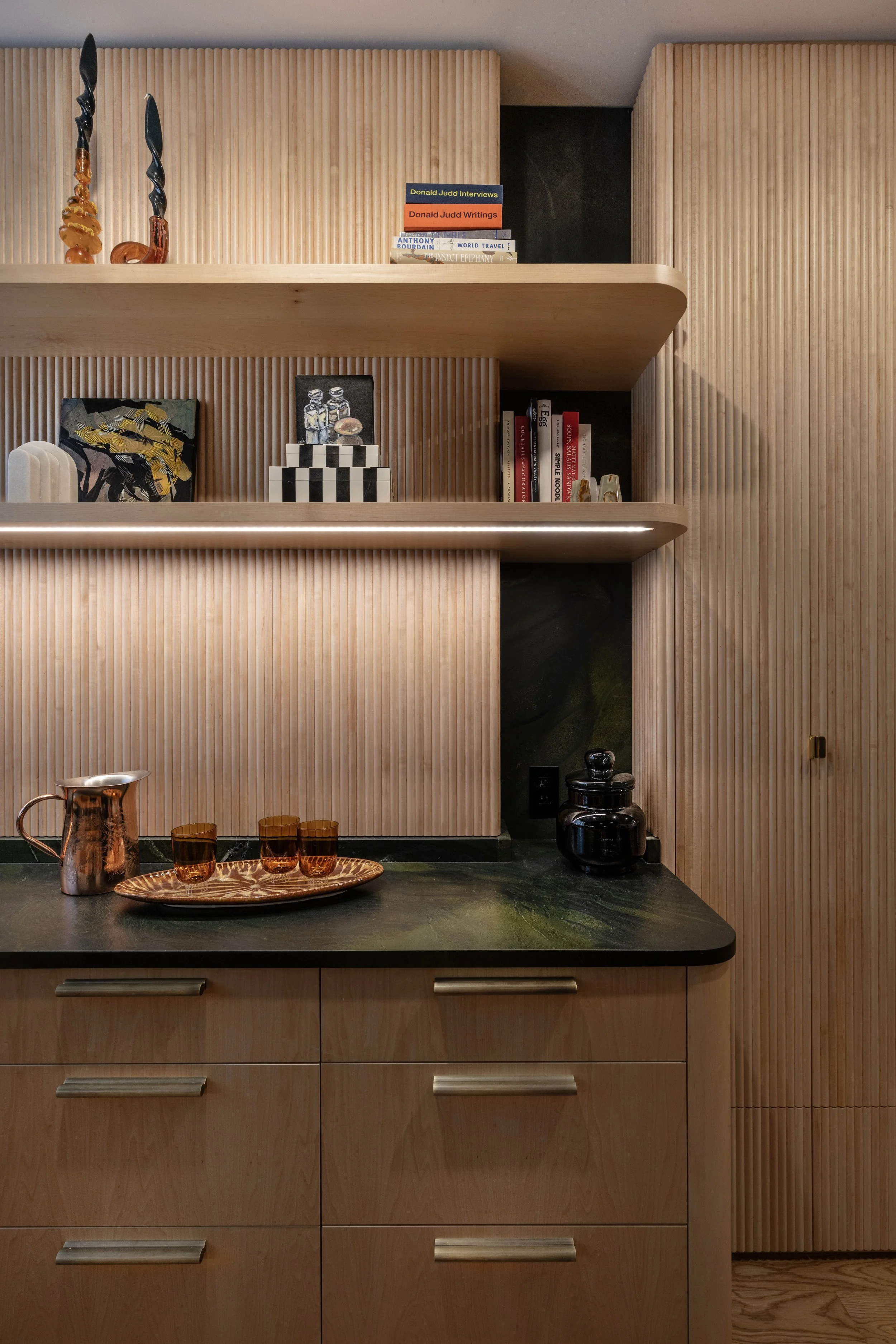 Millwork detail: Custom fluted wood kitchen cabinetry with sculptural detailing in a Brooklyn duplex.