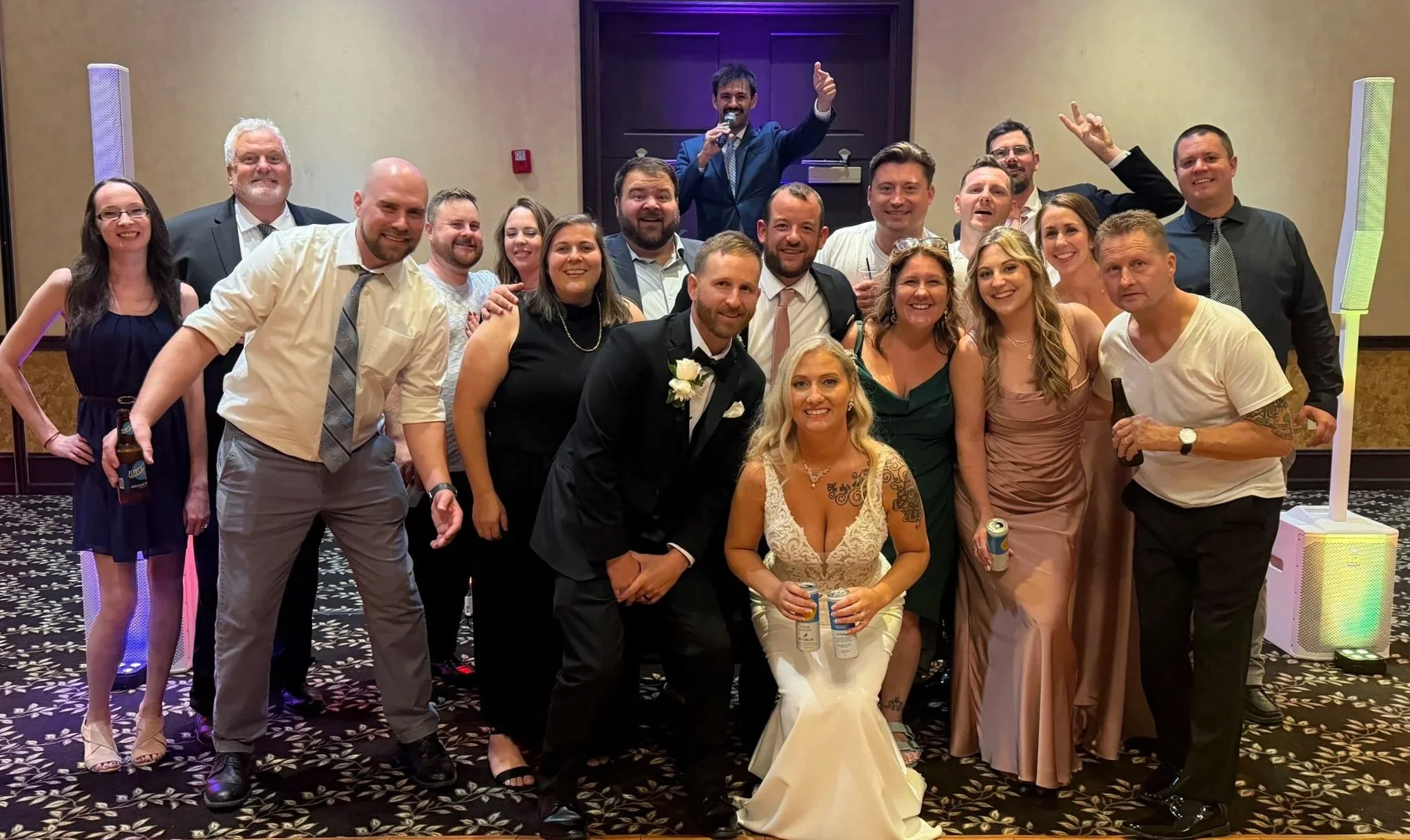 Group of people at a wedding reception in front of the DJ, including a bride and groom, in Cleveland, OH.
