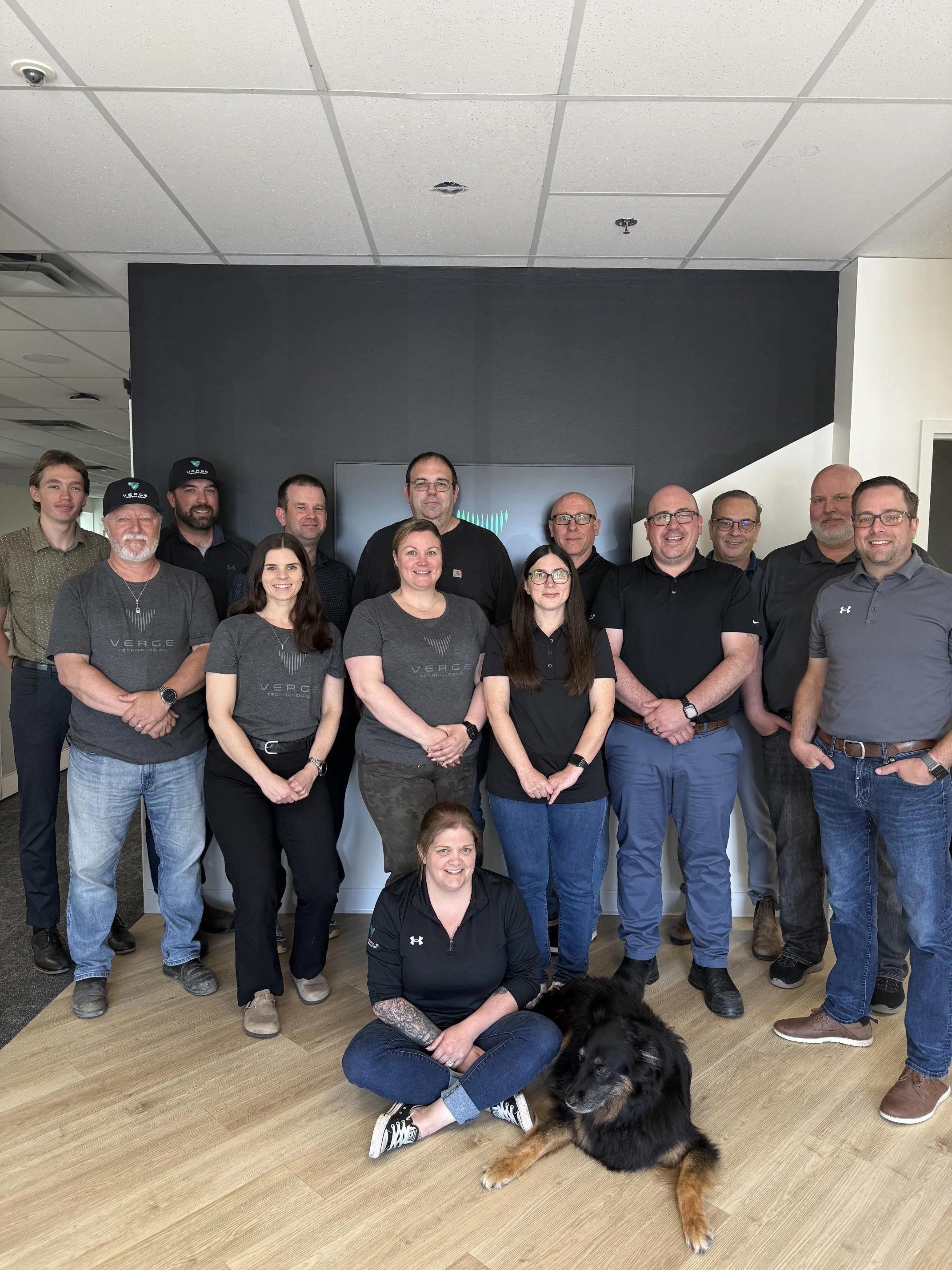 The Verge Technologies team standing and sitting in their Dartmouth office lobby.