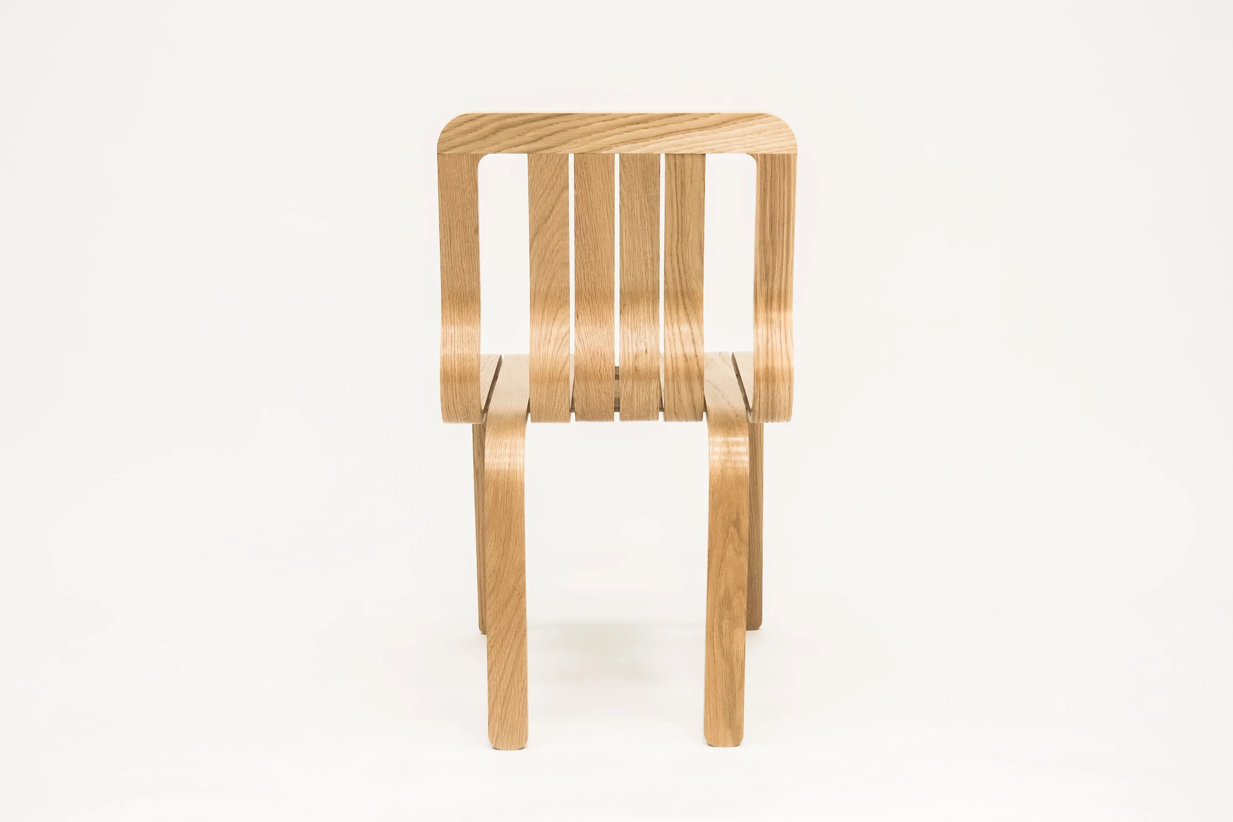 Empty wooden chair with slatted backrest against a white background.