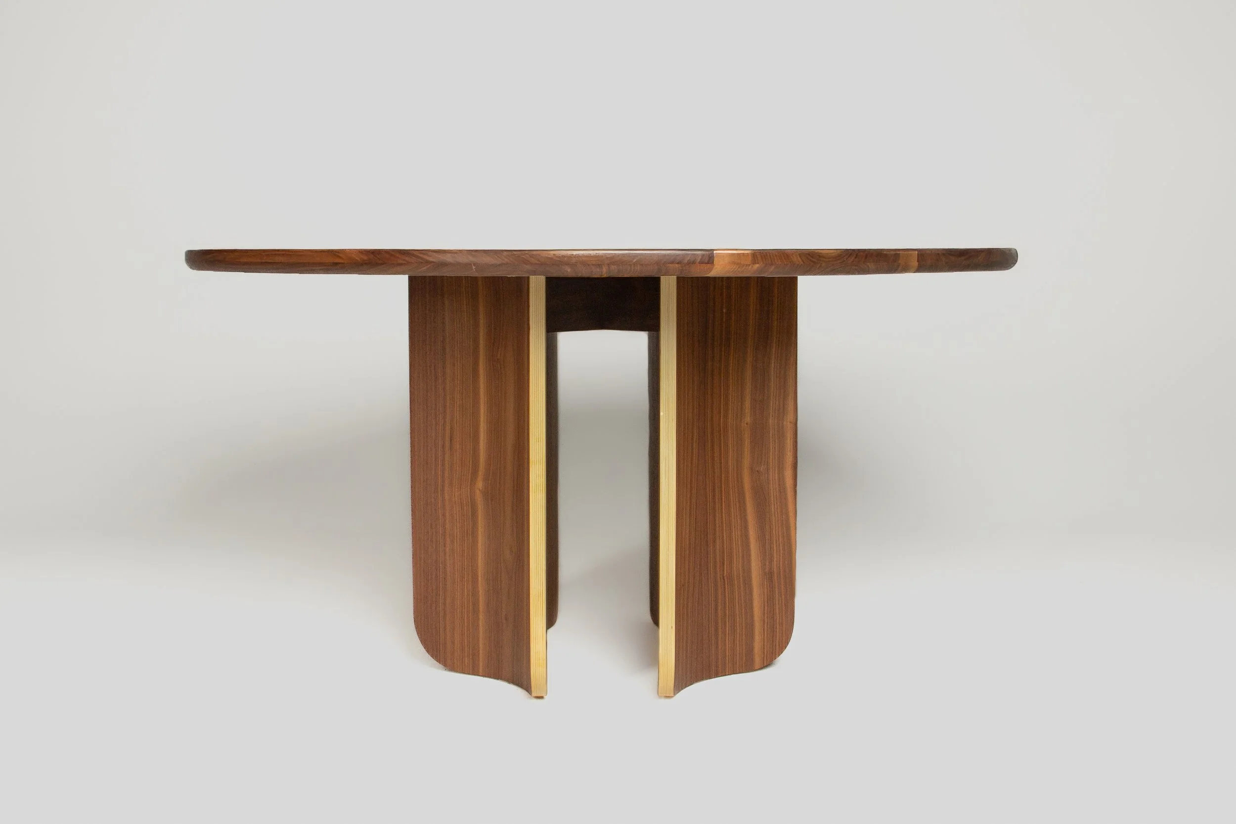 A wooden table with a rectangular top and curved legs, made of dark and light wood, set against a plain white background.