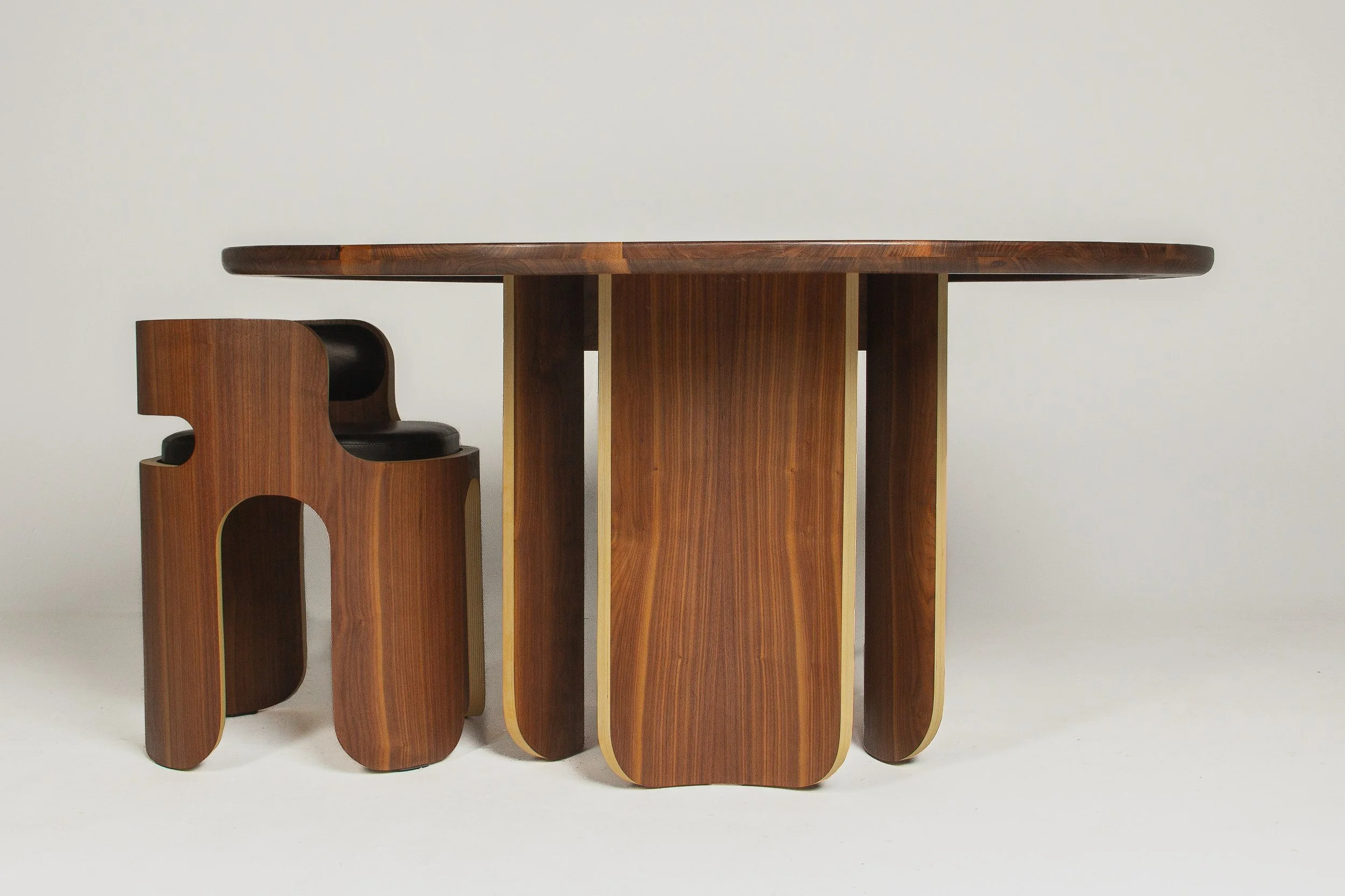 A wooden table with an irregular shape and matching wooden chairs with curved edges against a plain white background.