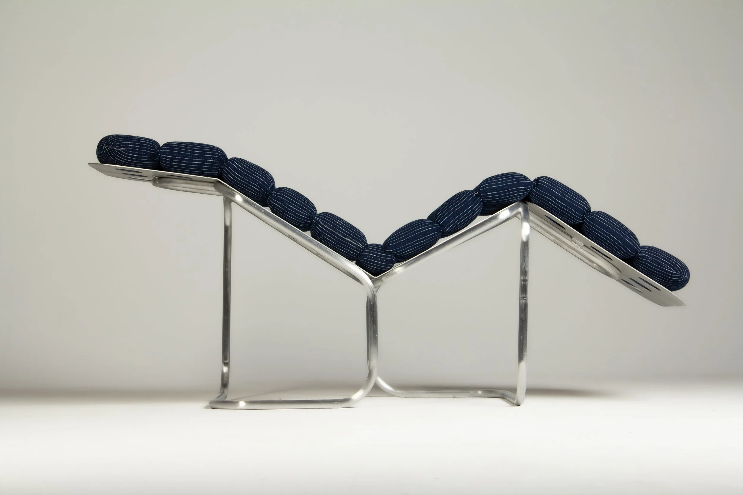 Sculpture of a wireframe smiling mouth with blue striped fabric teeth.