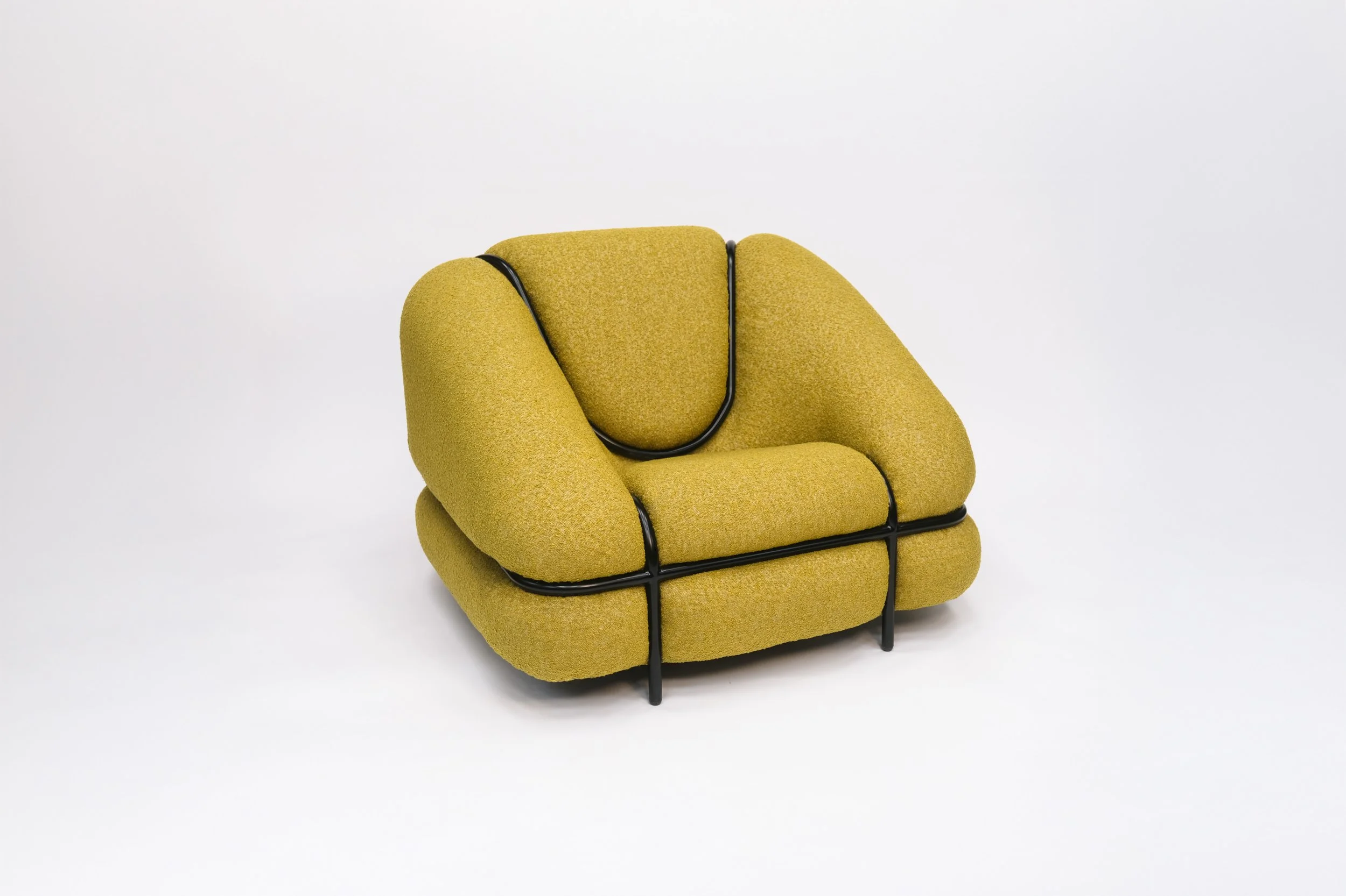 Modern mustard yellow upholstered armchair with black metal frame on a white background.