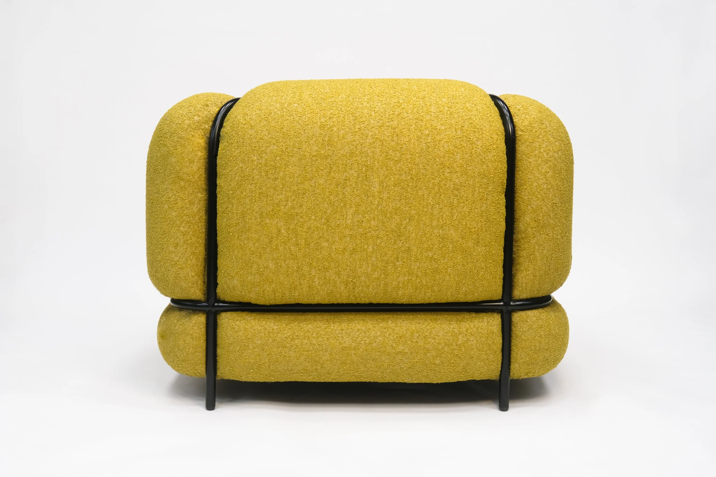 Modern yellow upholstered armchair with black metal frame on a plain white background.