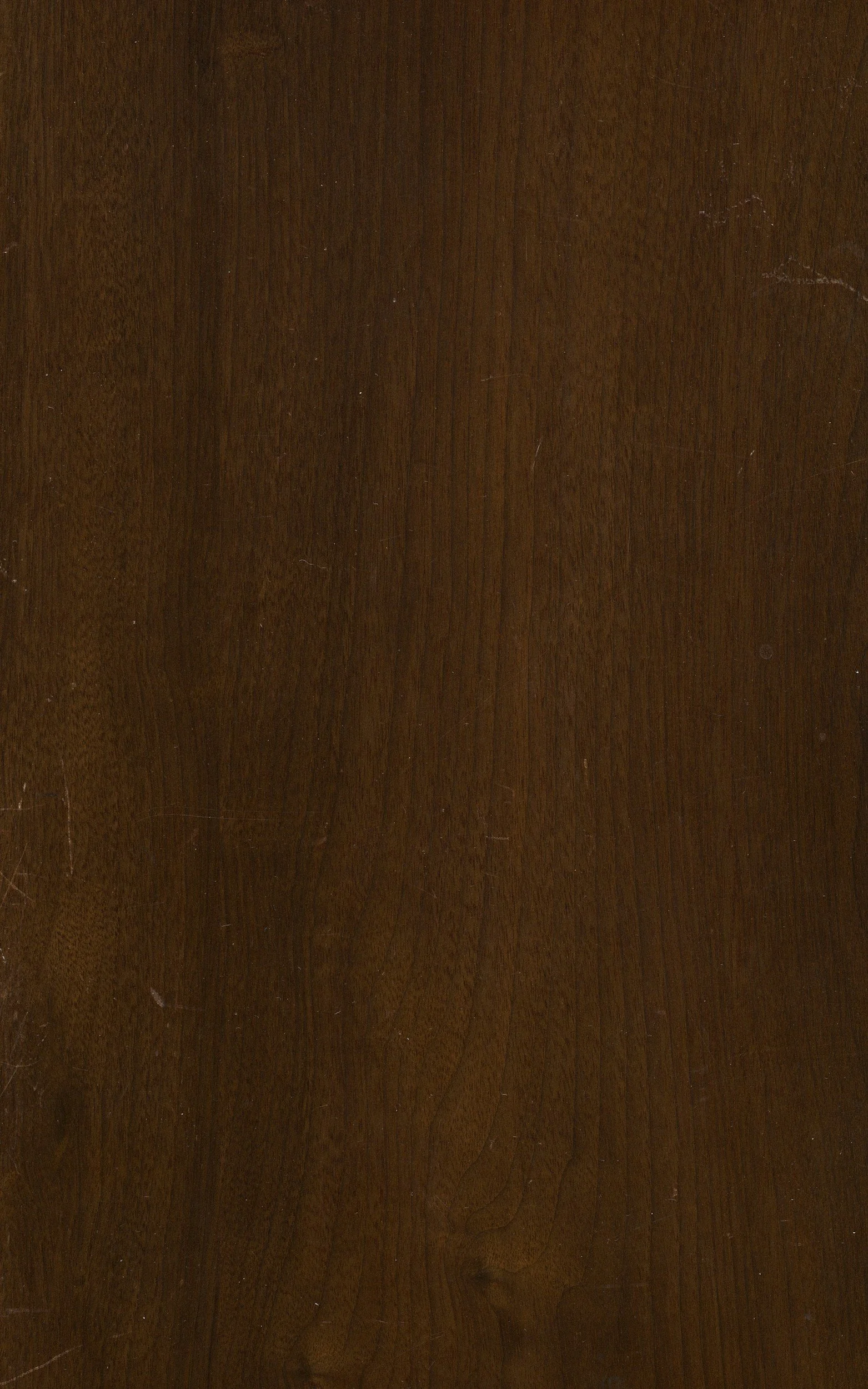 A close-up of a wooden surface with a dark brown finish.
