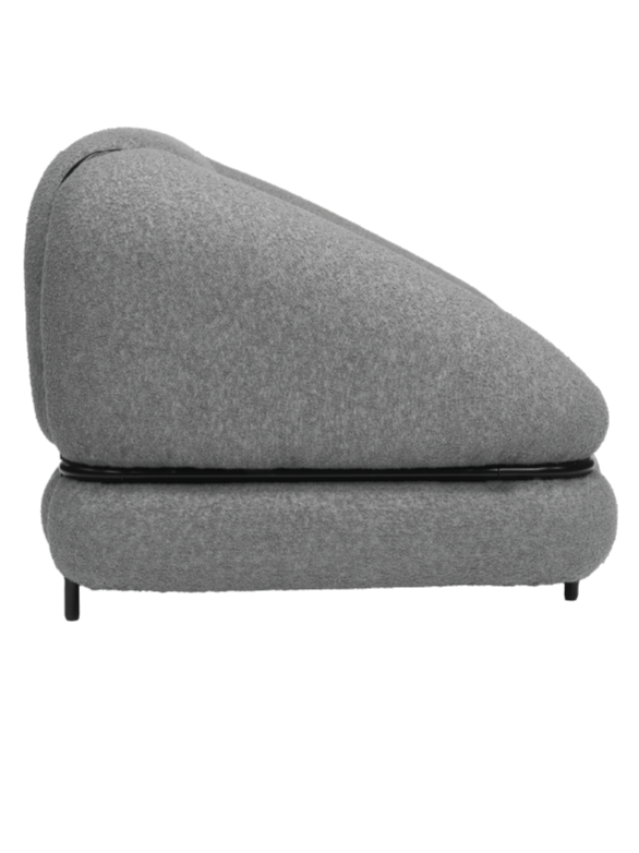 A modern, minimalist grey sofa with a unique, curved shape and a black base.