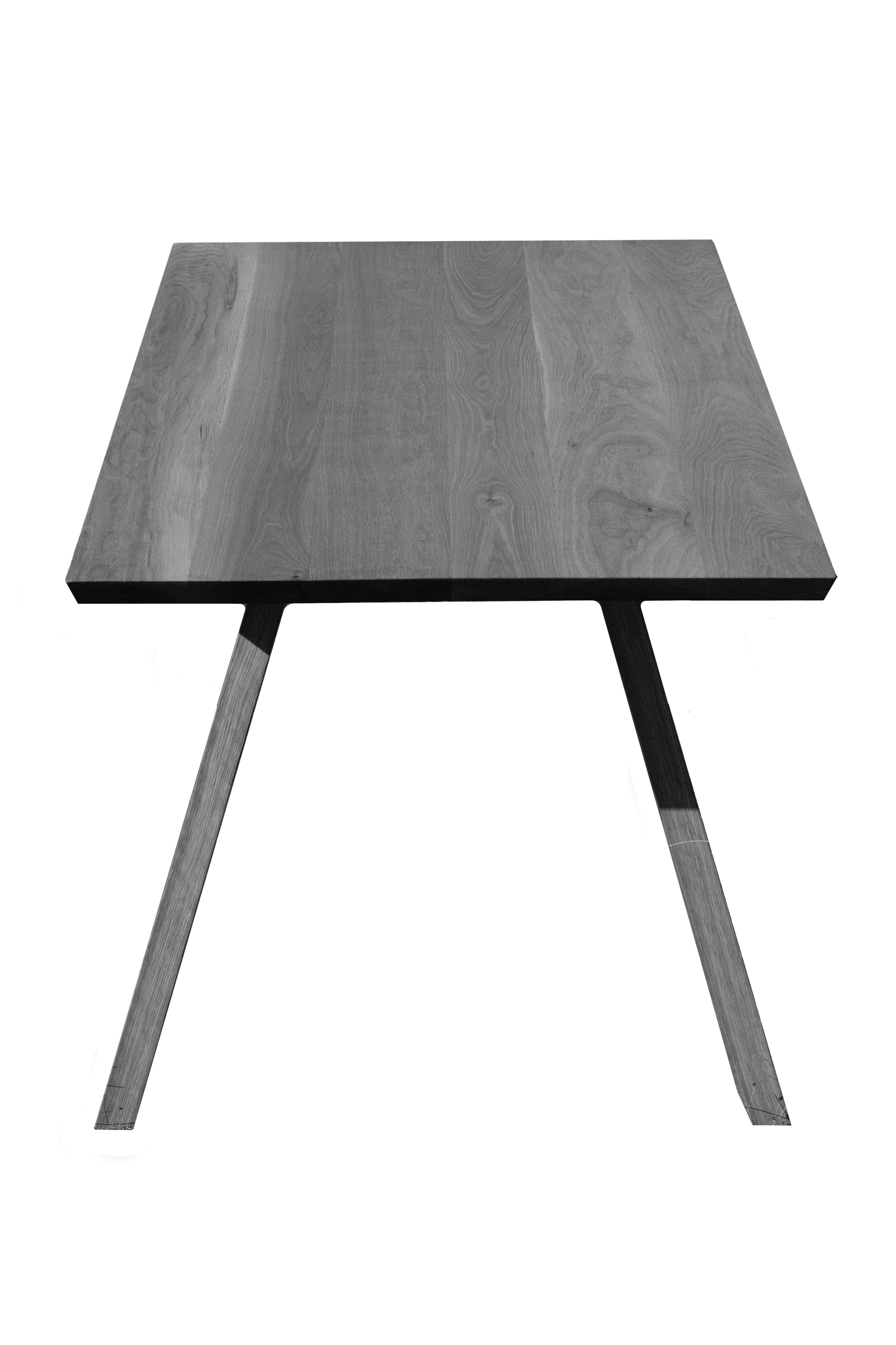 A wooden table with a rectangular top and four angled legs against a black background.