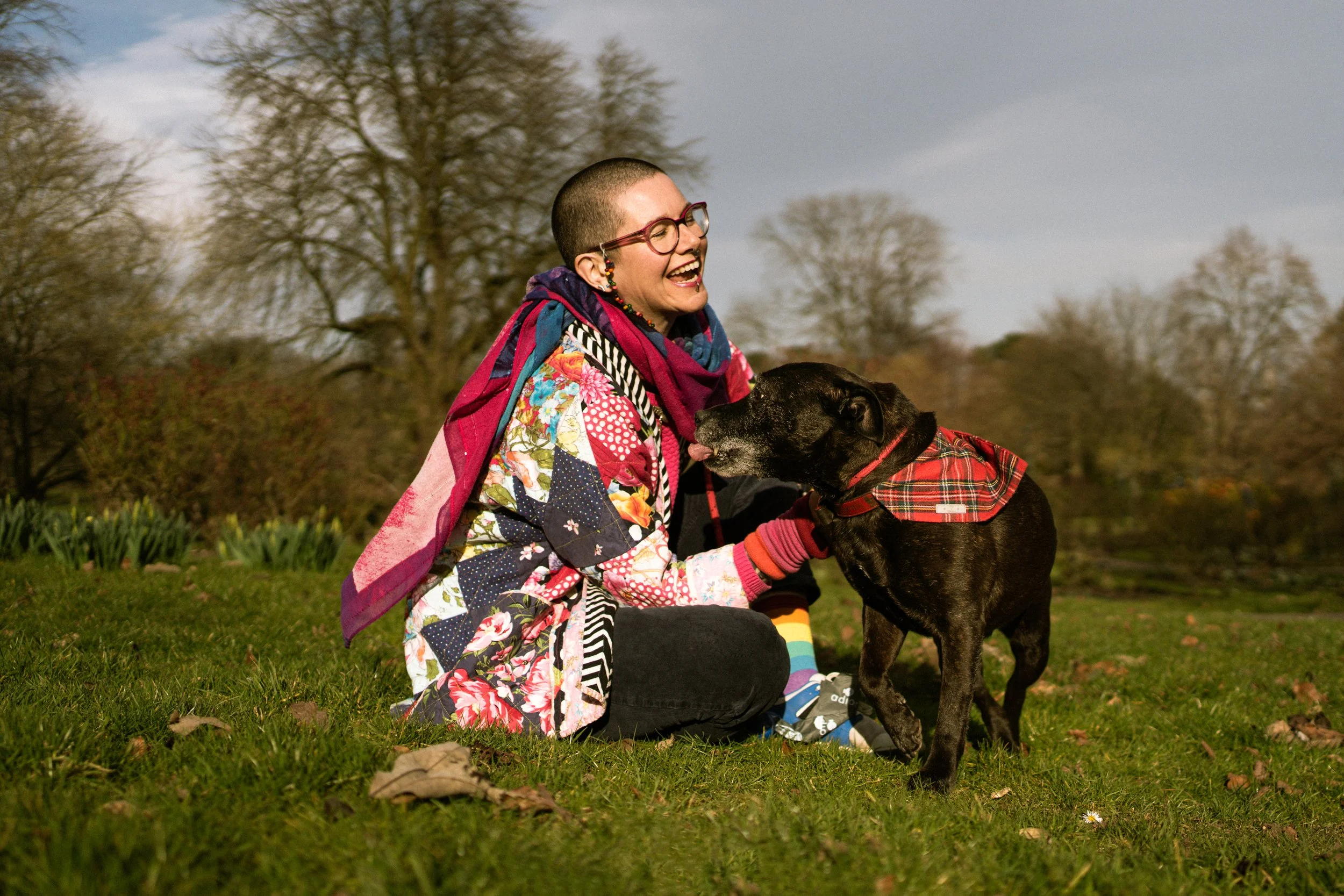 A woman and her dog playing happily in the park