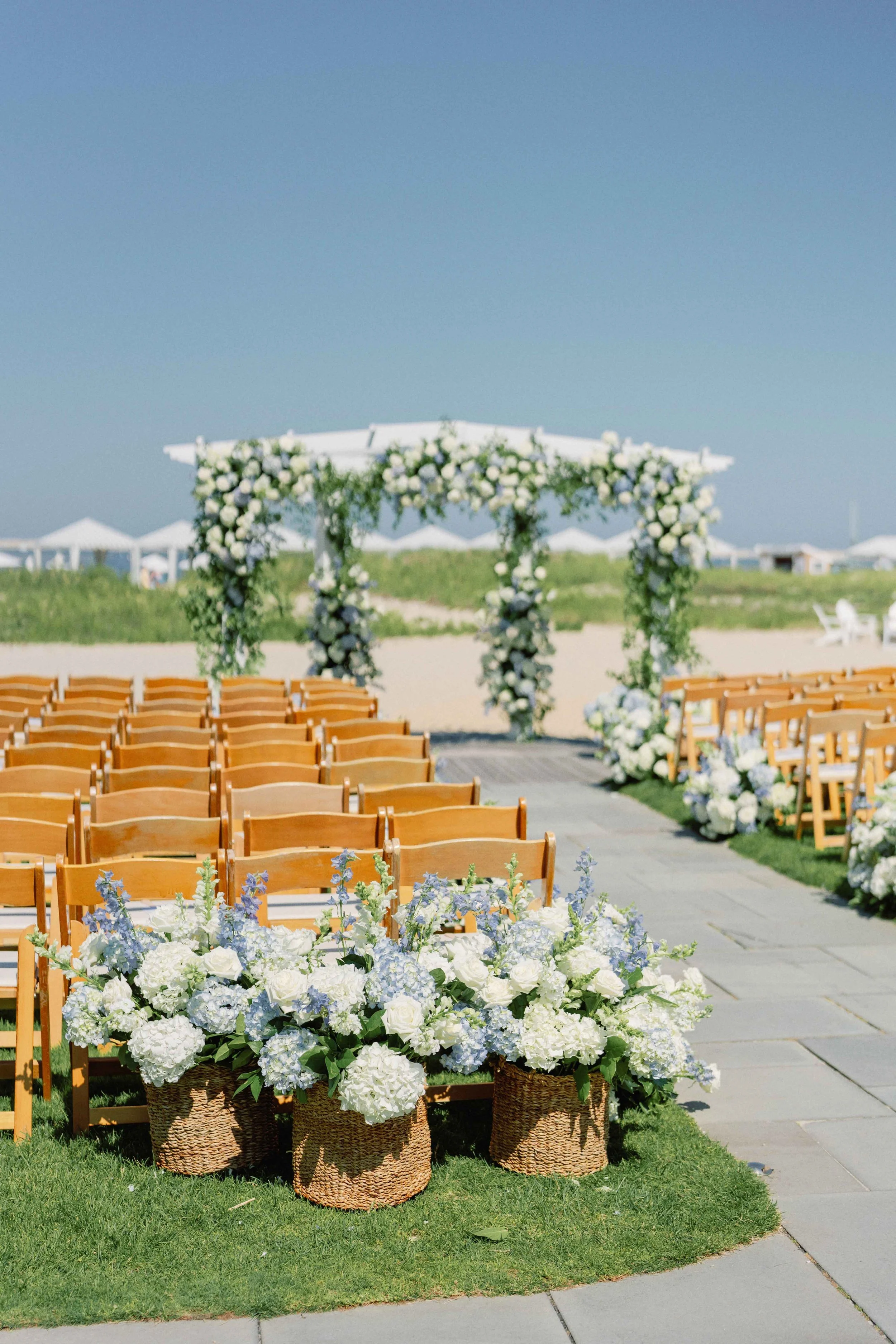 Gorgeous wedding ceremony set-up featuring florals and wedding guest chairs on the Massachusetts coast