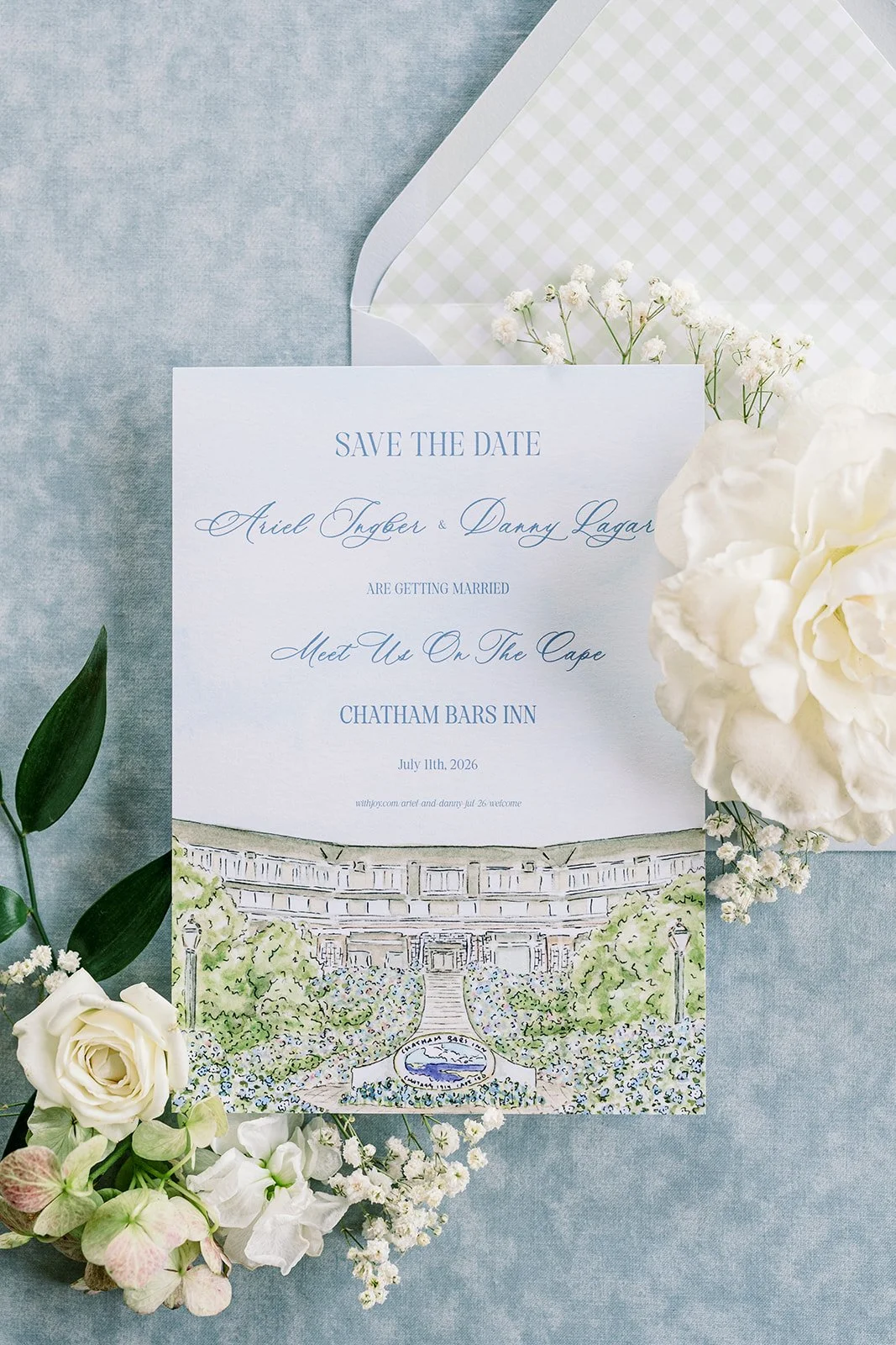Wedding save the date card with floral border and watercolor illustration of a building, surrounded by white and green flowers.