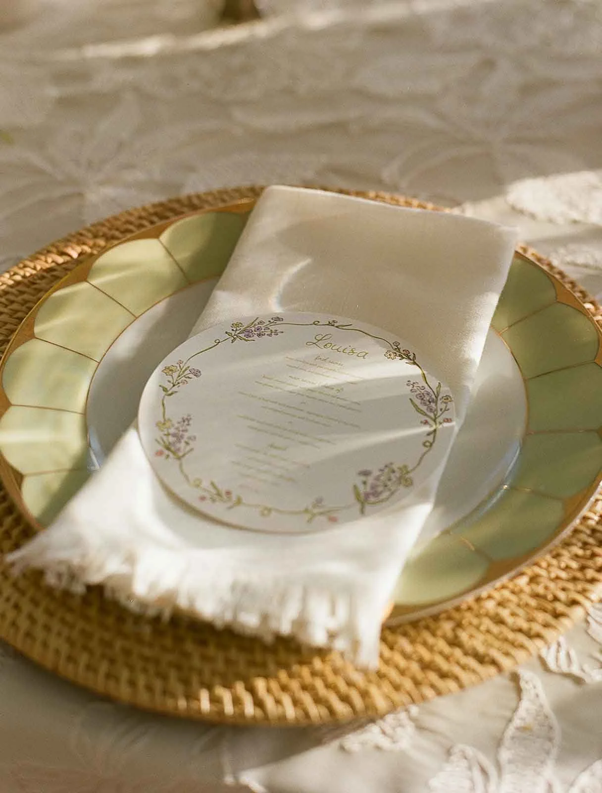 Green plate with place mat, napkin, and custom circle menu for a luxury outdoor wedding