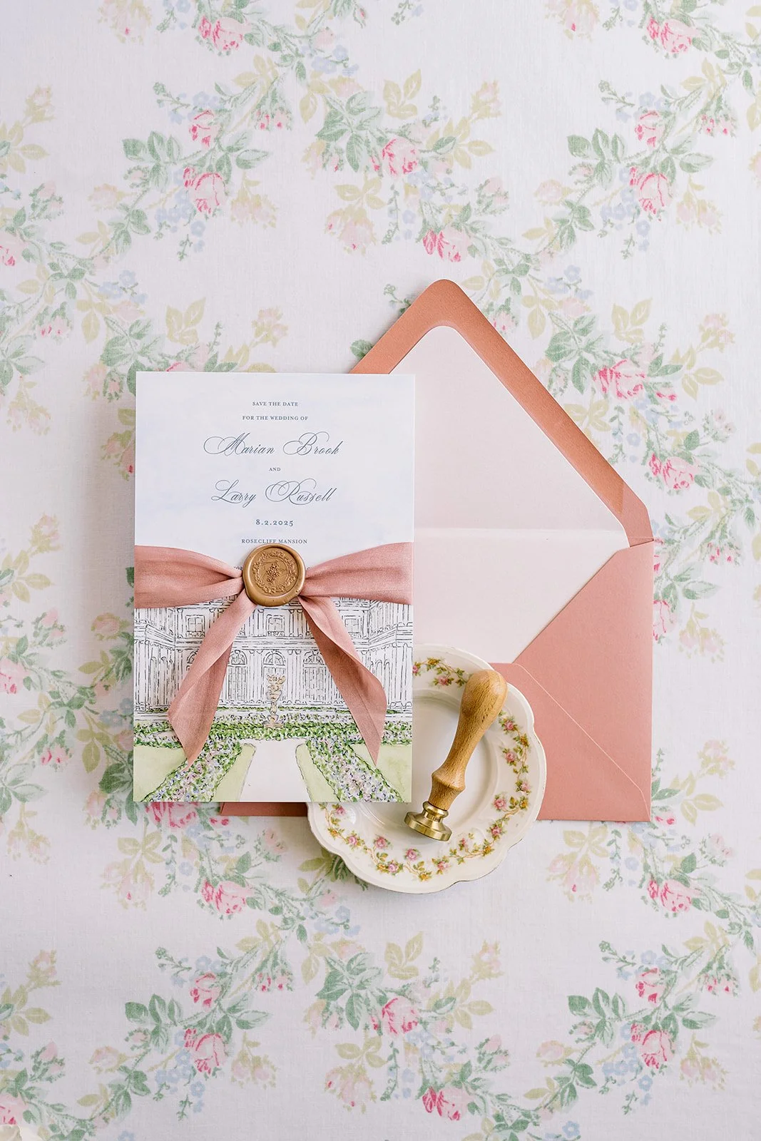 Romantic and pink wedding stationery created by a watercolor artist featuring the invitation and a pink envelope on a floral background with a wax stamp seal stamp

