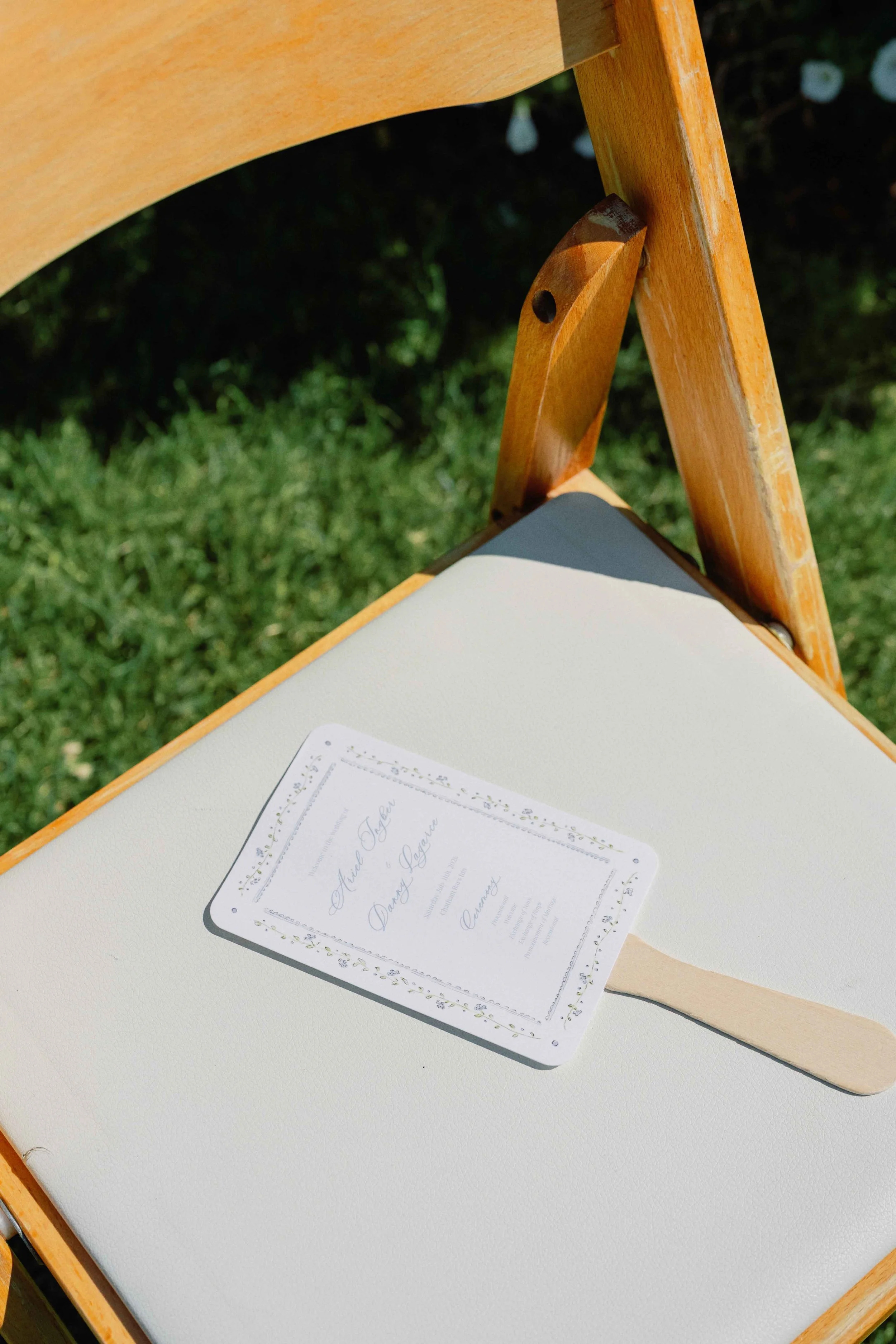 Wedding program and fan set on top of a ceremony chair