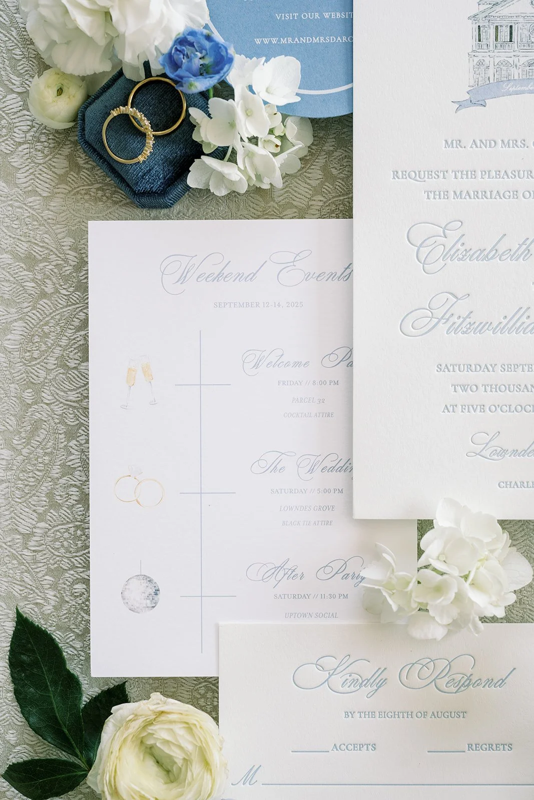 Elegant weekend events card with invitations and other wedding stationery with real florals surrounding it