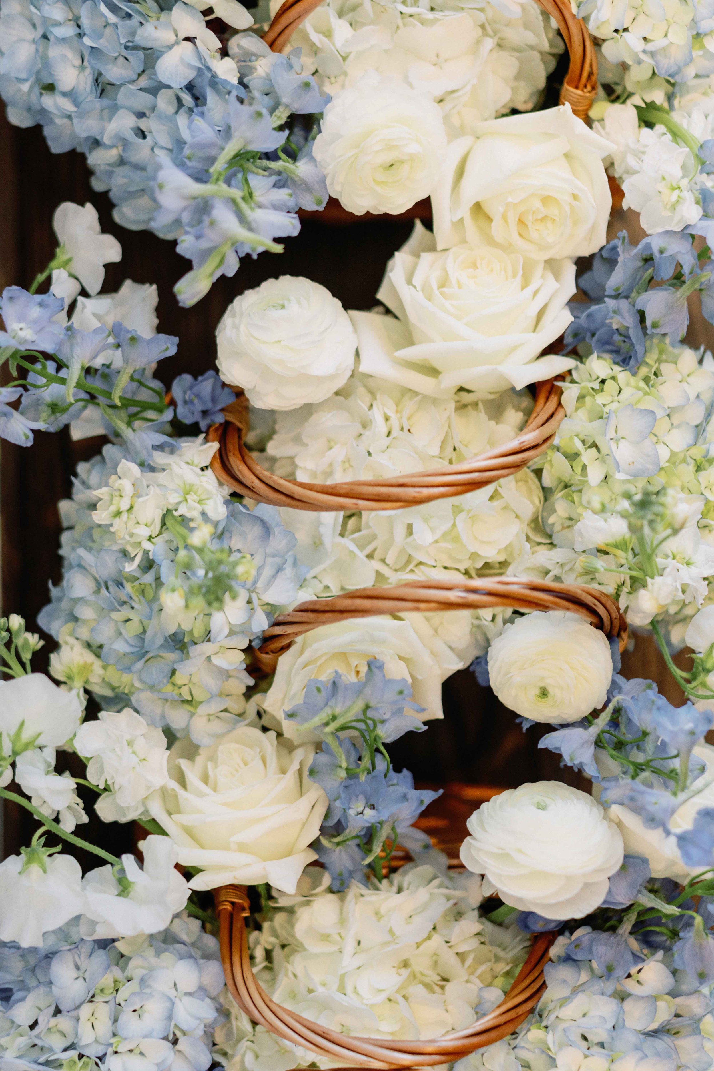 Baskets of blue and white florals for a coastal wedding day