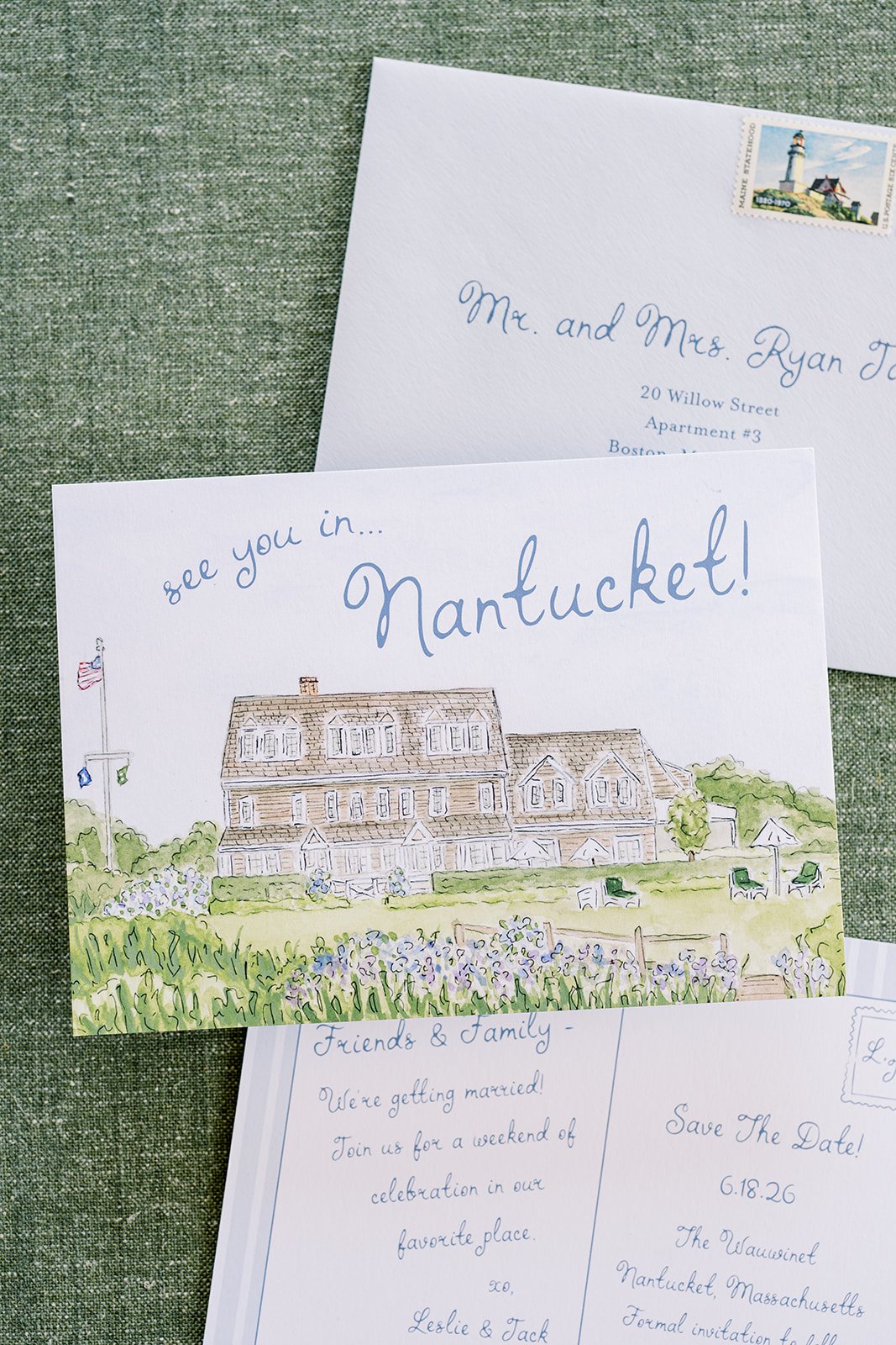 A watercolor-style wedding invitation with the headline 'see you in... Nantucket!' featuring a watercolor painting of a house surrounded by greenery with additional wedding stationery behind it.
