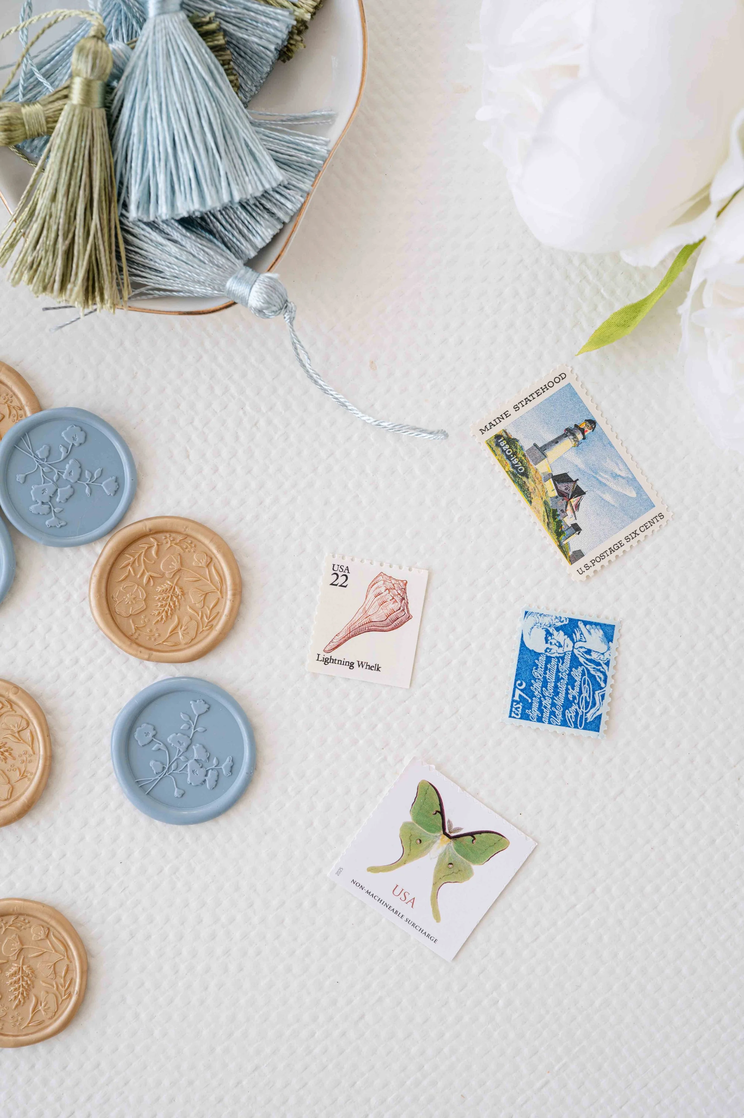 Various tassels, wax seals, and stamps on a neutral surface