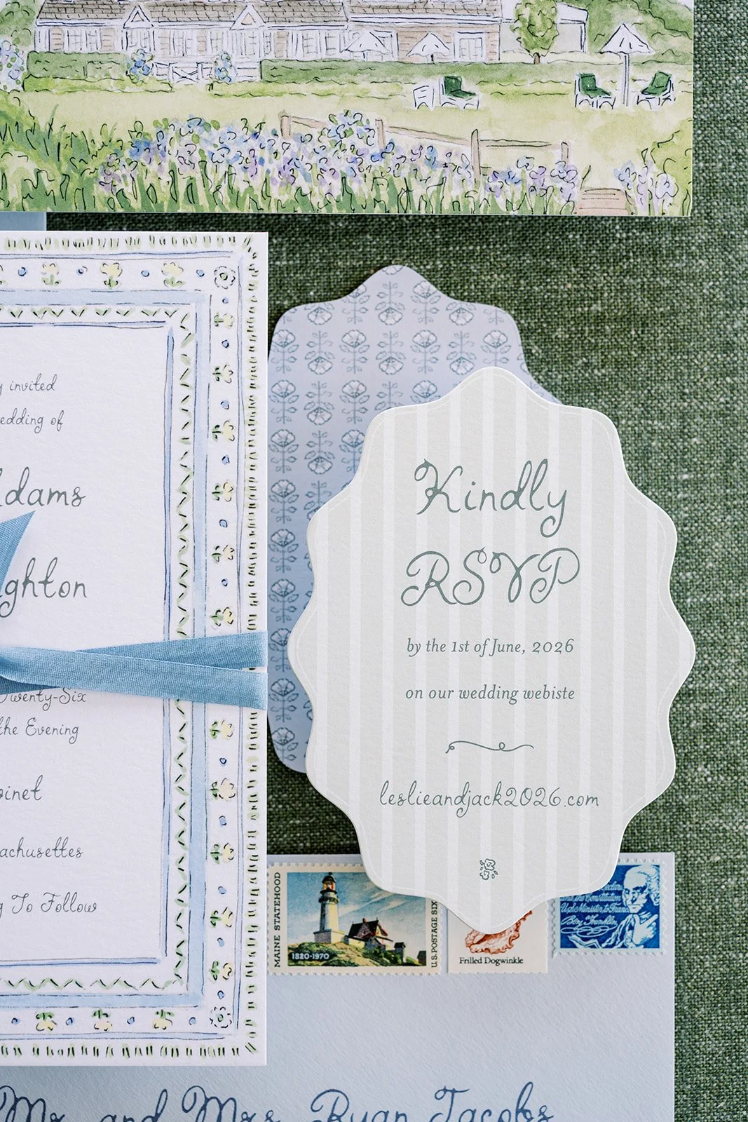 A wedding RSVP card next to a floral watercolor border wedding invitation suite on a green textured surface and additional wedding invitation suite details.