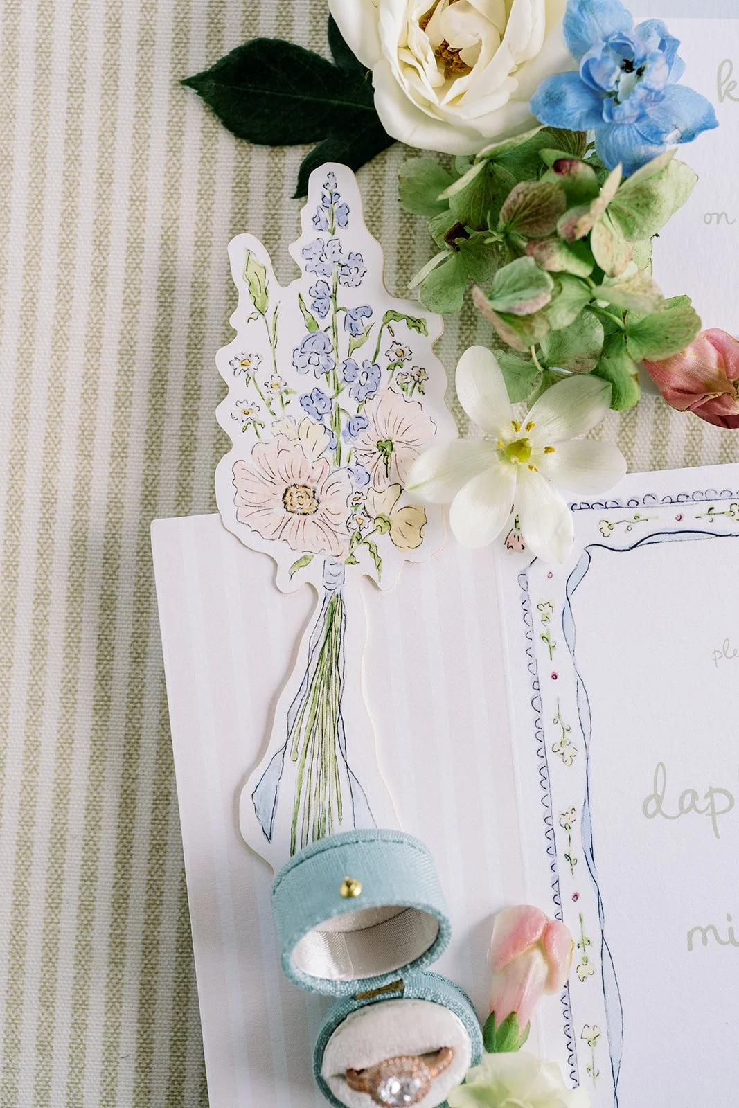 Watercolor floral cut out on a wedding invitation with wedding details
