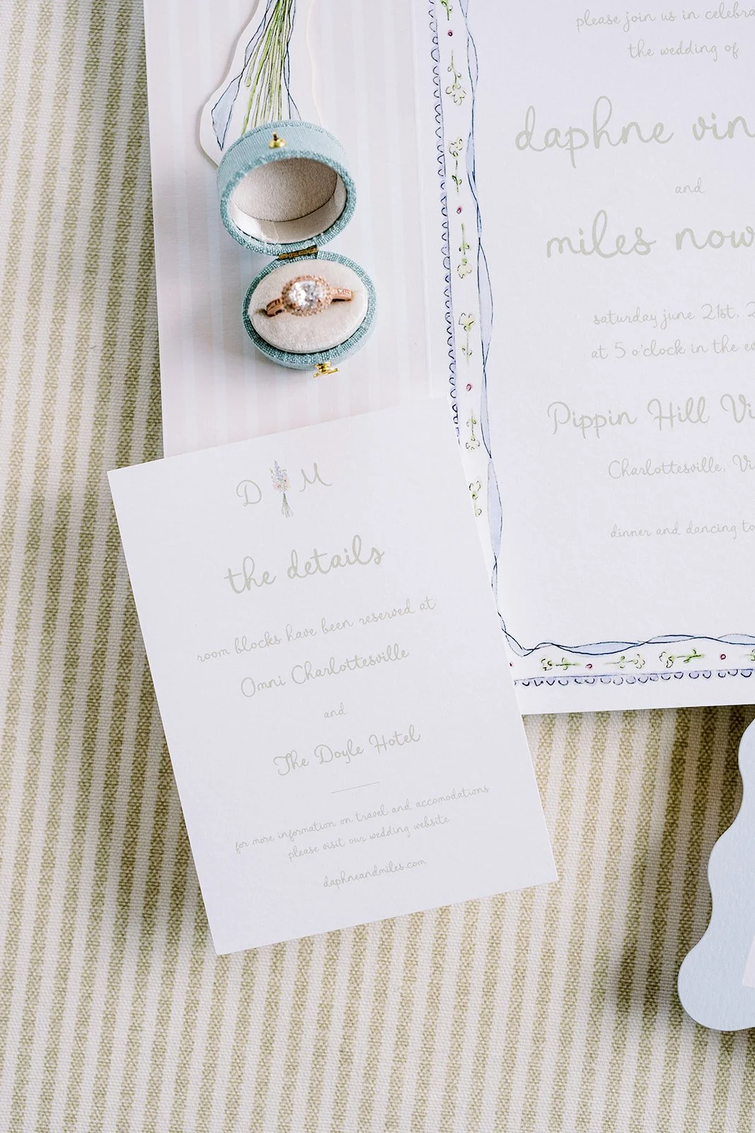 Floral wedding invitation suite created by a watercolor artist featuring a details card, ring, and invitation
