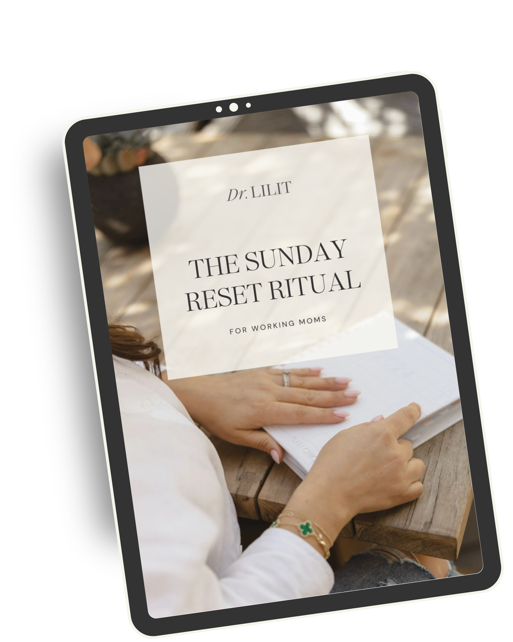 Digital device displaying a cover for a workshop titled 'The Sunday Reset Ritual for Working Moms' by Dr. Lilit, with a blurred background of a person’s hands resting on a notebook on a wooden table.