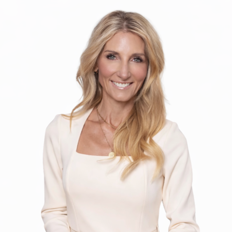 A smiling woman with long blonde hair, wearing a white top and a delicate necklace, standing against a plain white background.