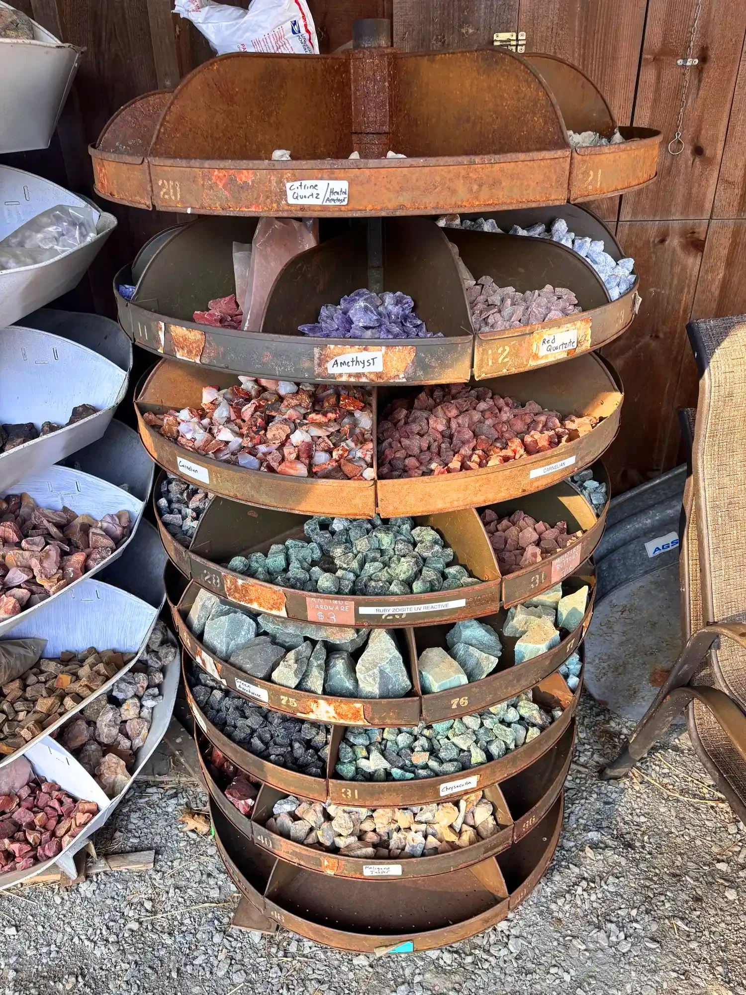 shop-exterior-outdoor-rusty-tiered-rack-citrine-amethyst-carnelian-ruby-zoisite-freds-rock-shop-putney-vt-hero.webp