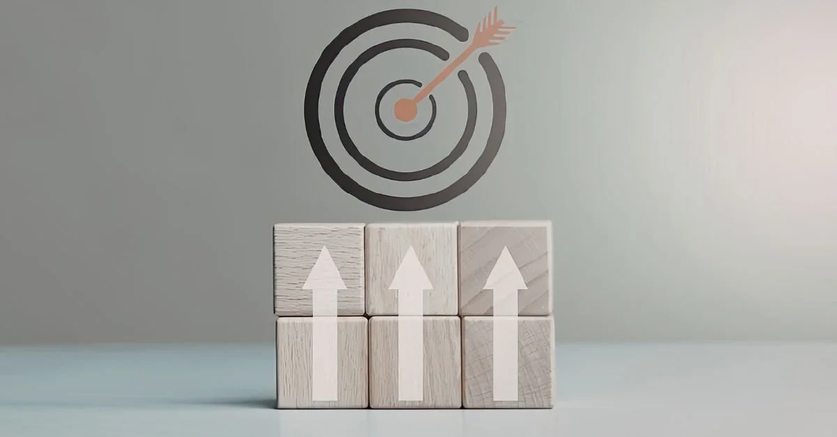 Six wooden blocks with white upward arrows, arranged in two rows of three, in front of a target with an arrow hitting the bullseye.