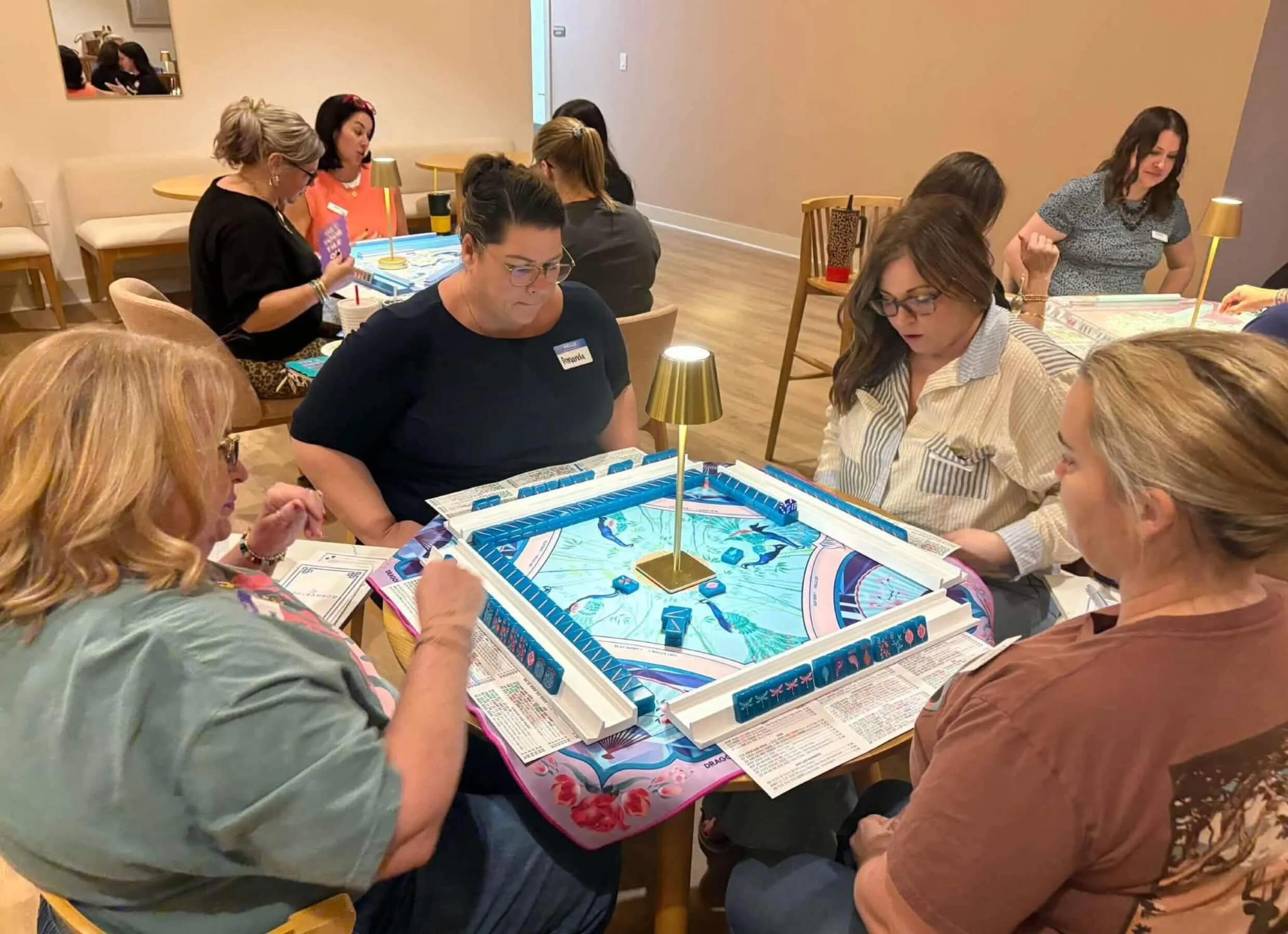 A group of women playing a board game together in a cozy room with warm lighting.