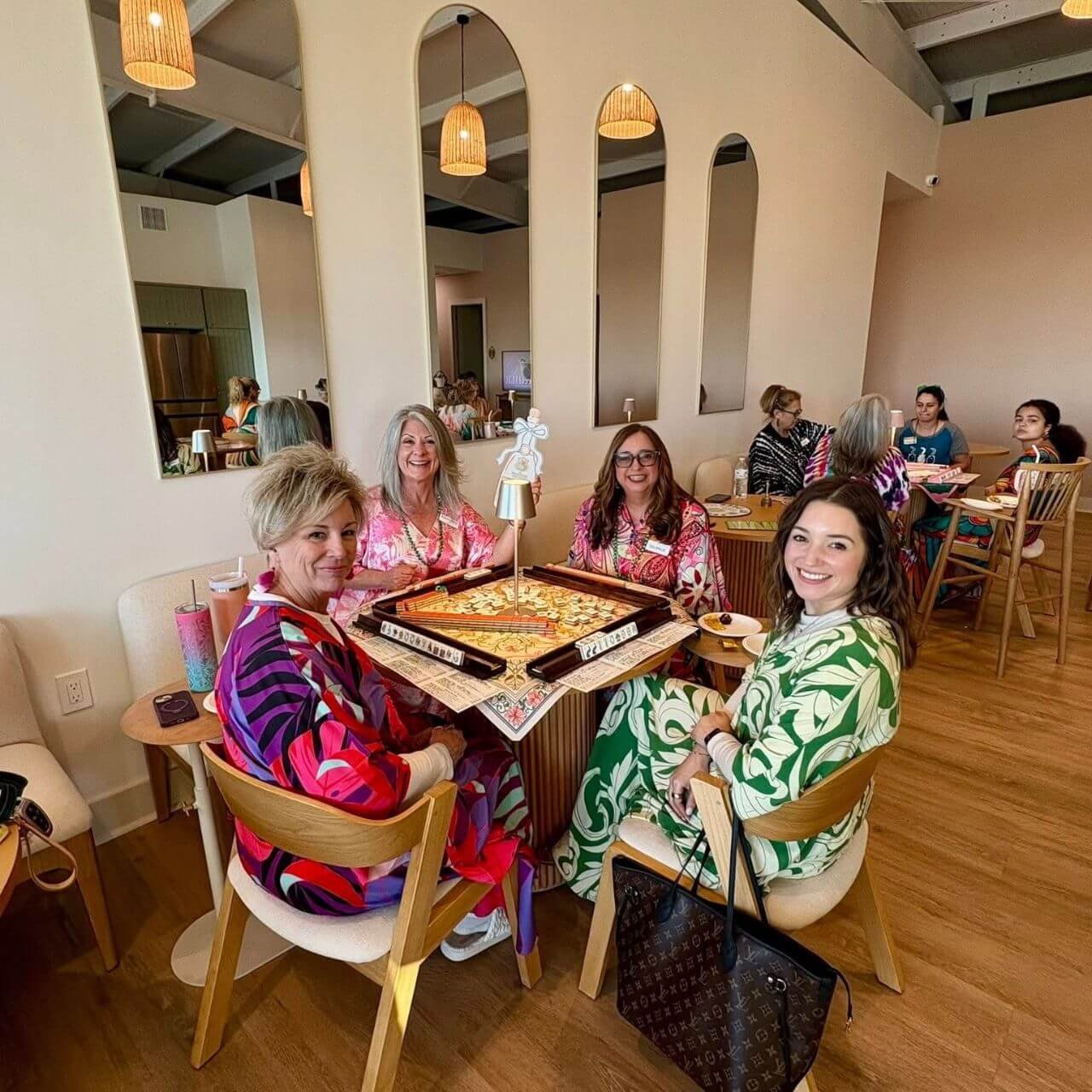 Women playing Mahjong for Themed Open Play Night wearing MuuMuu's 