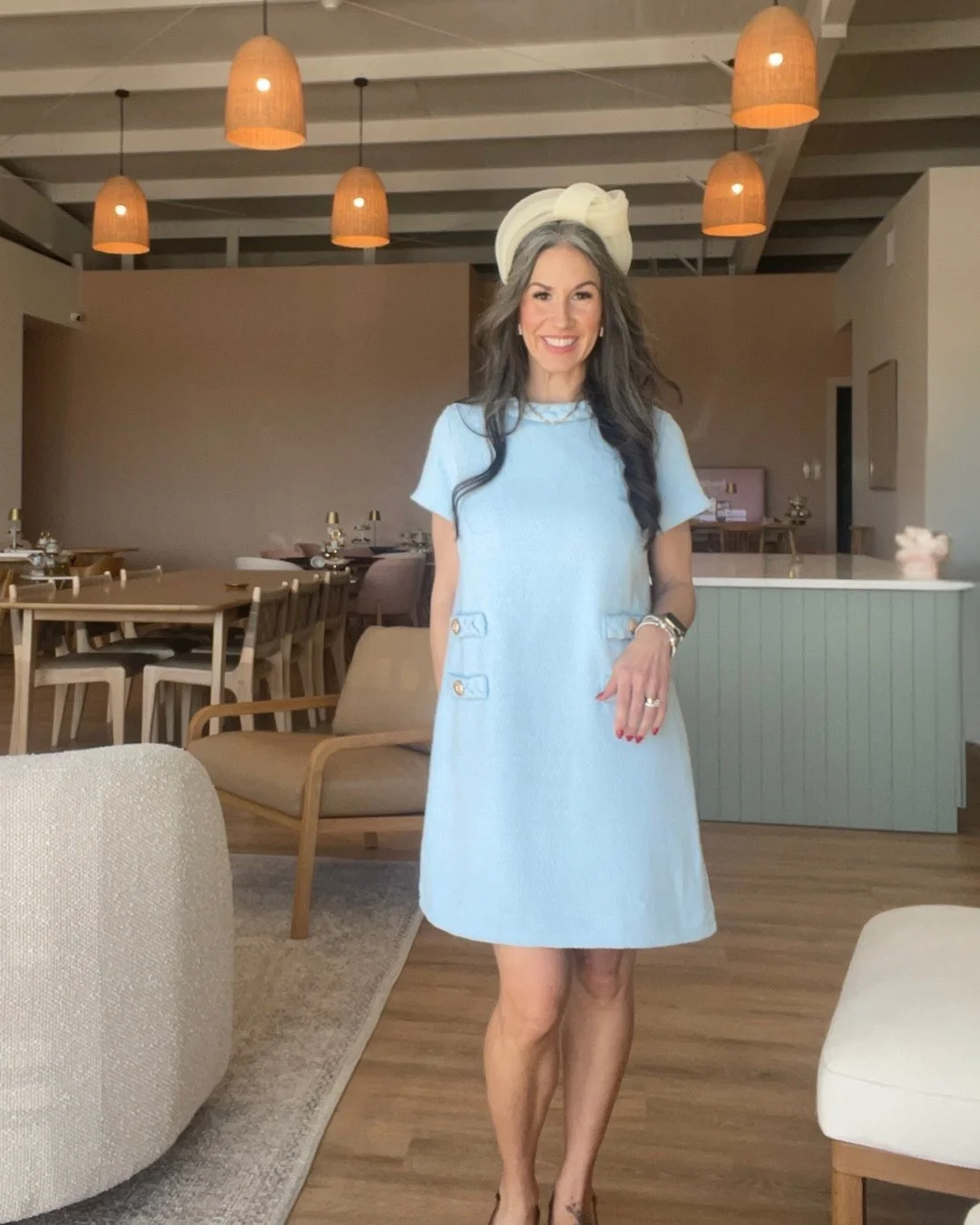 Women with long dark hair wearing a blue dress and a tea party hat