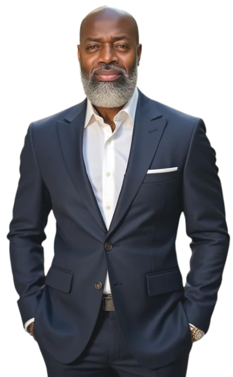 A man in a dark blue suit with a white shirt, standing confidently with hands in pockets.