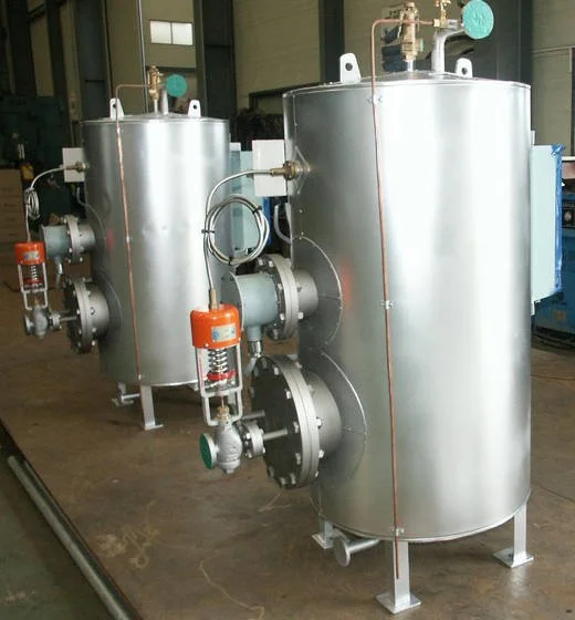 Three large stainless steel industrial tanks with pipes and gauges in a factory setting.