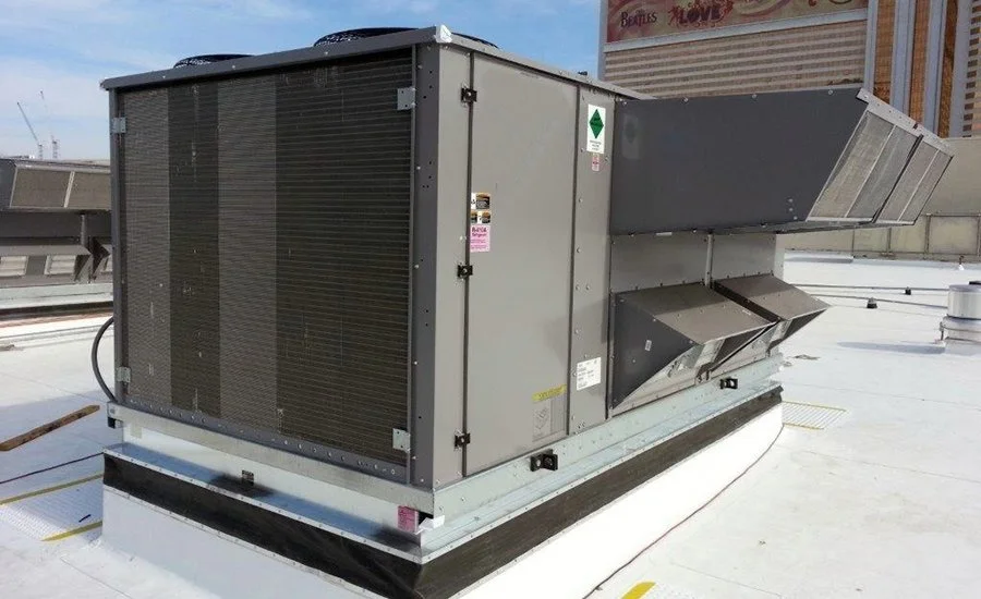 Commercial rooftop air conditioning unit with vents and fans.