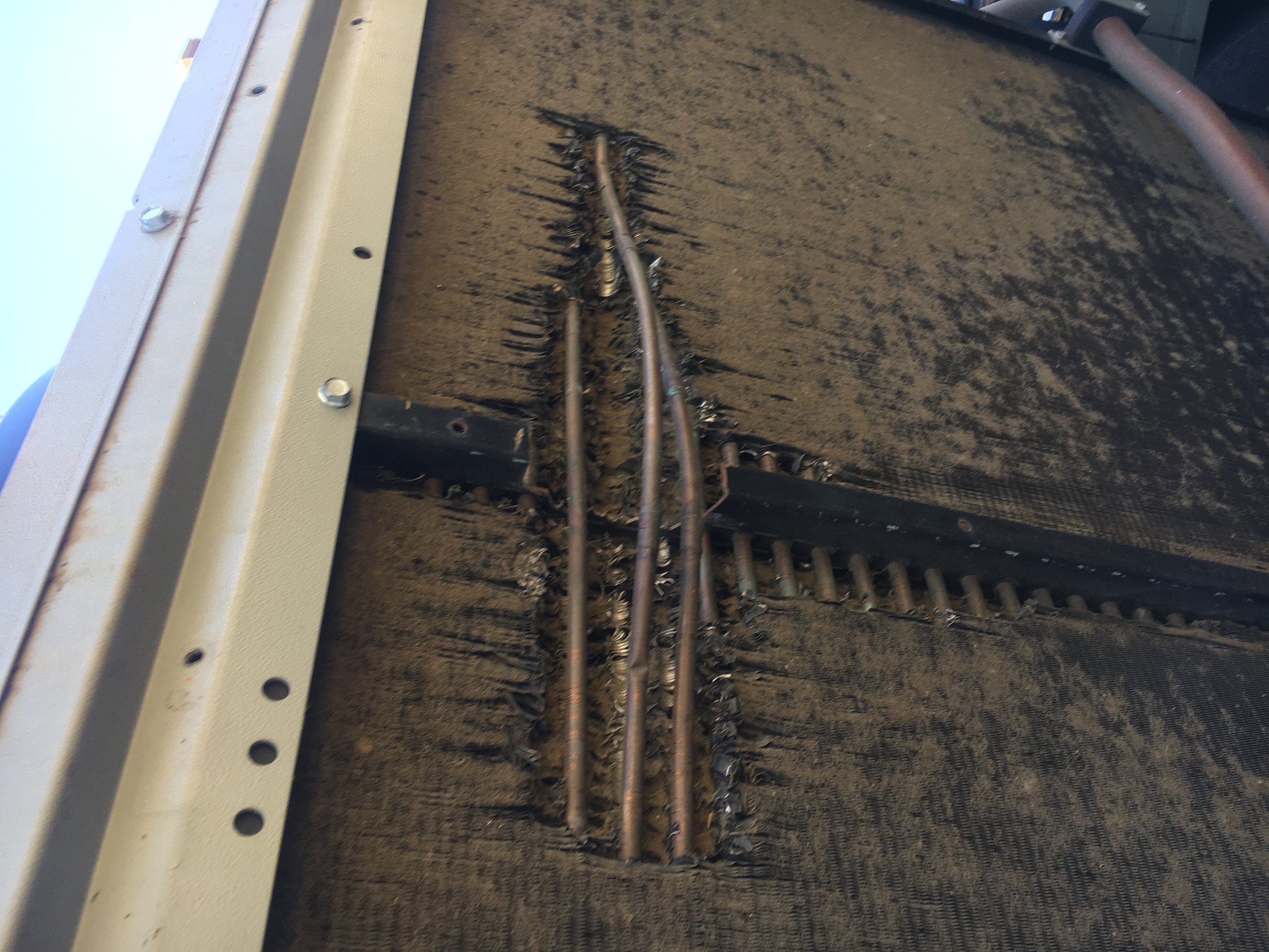 The interior of a piano, showing the brushed felt, metal wires, and metal pins used to produce sound.