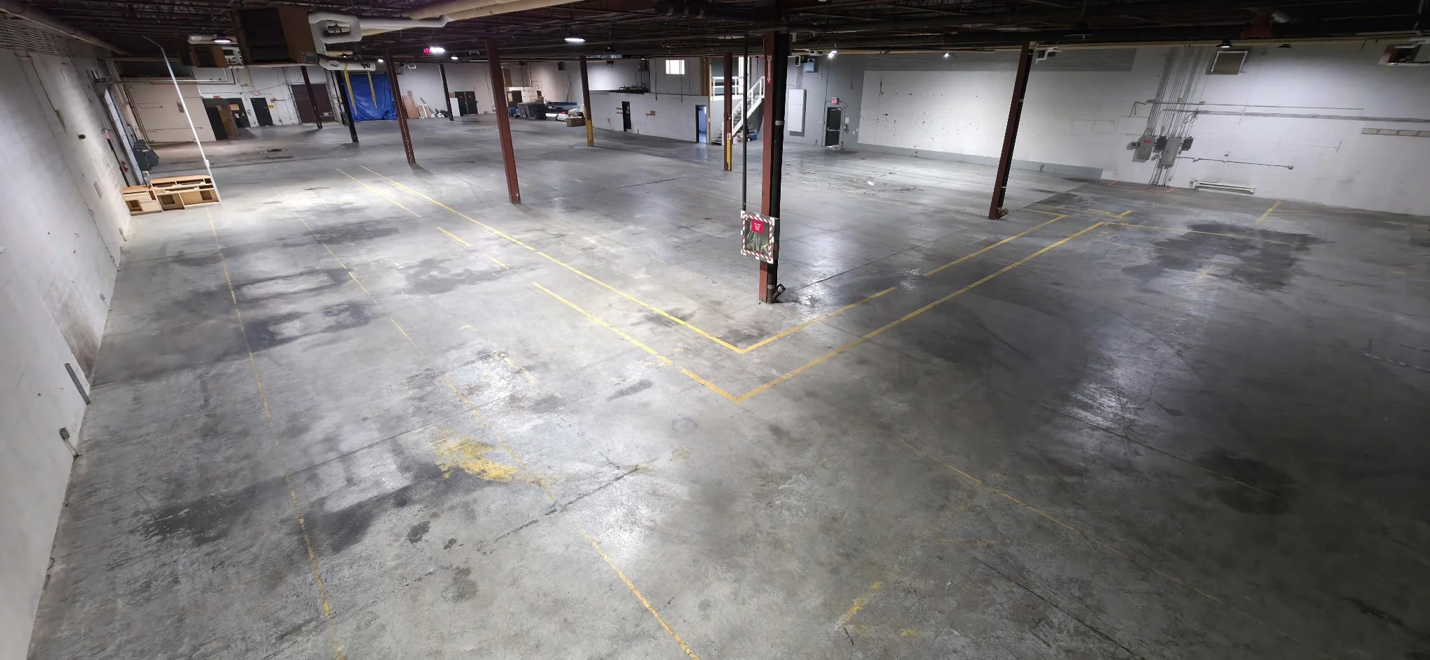 Large, open warehouse space with overhead dock doors, office mezzanine, private washroom, and private lunchroom.