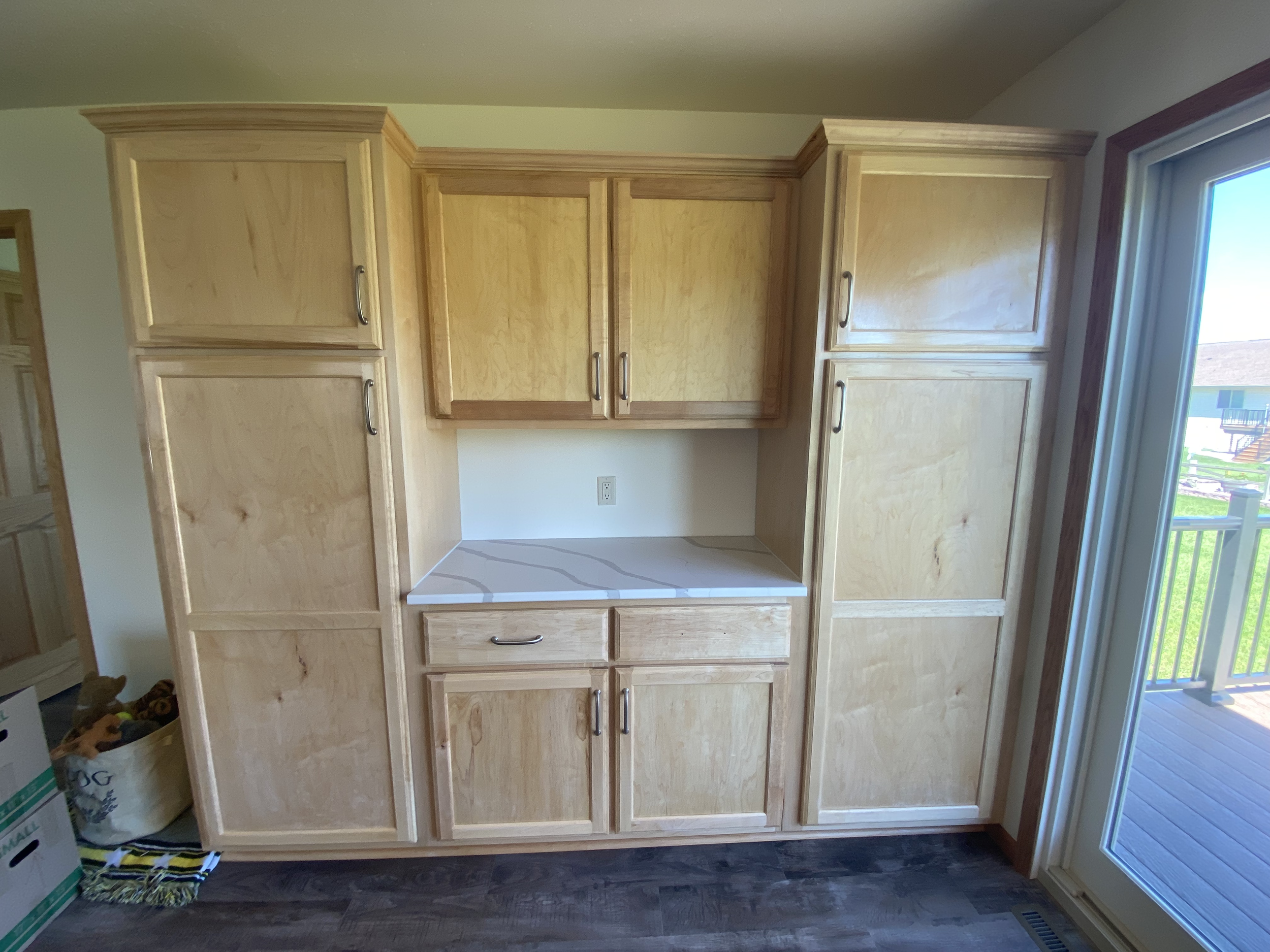 custom maple Wooden kitchen cabinets  built in with a small countertop below a window. storage, linen closet