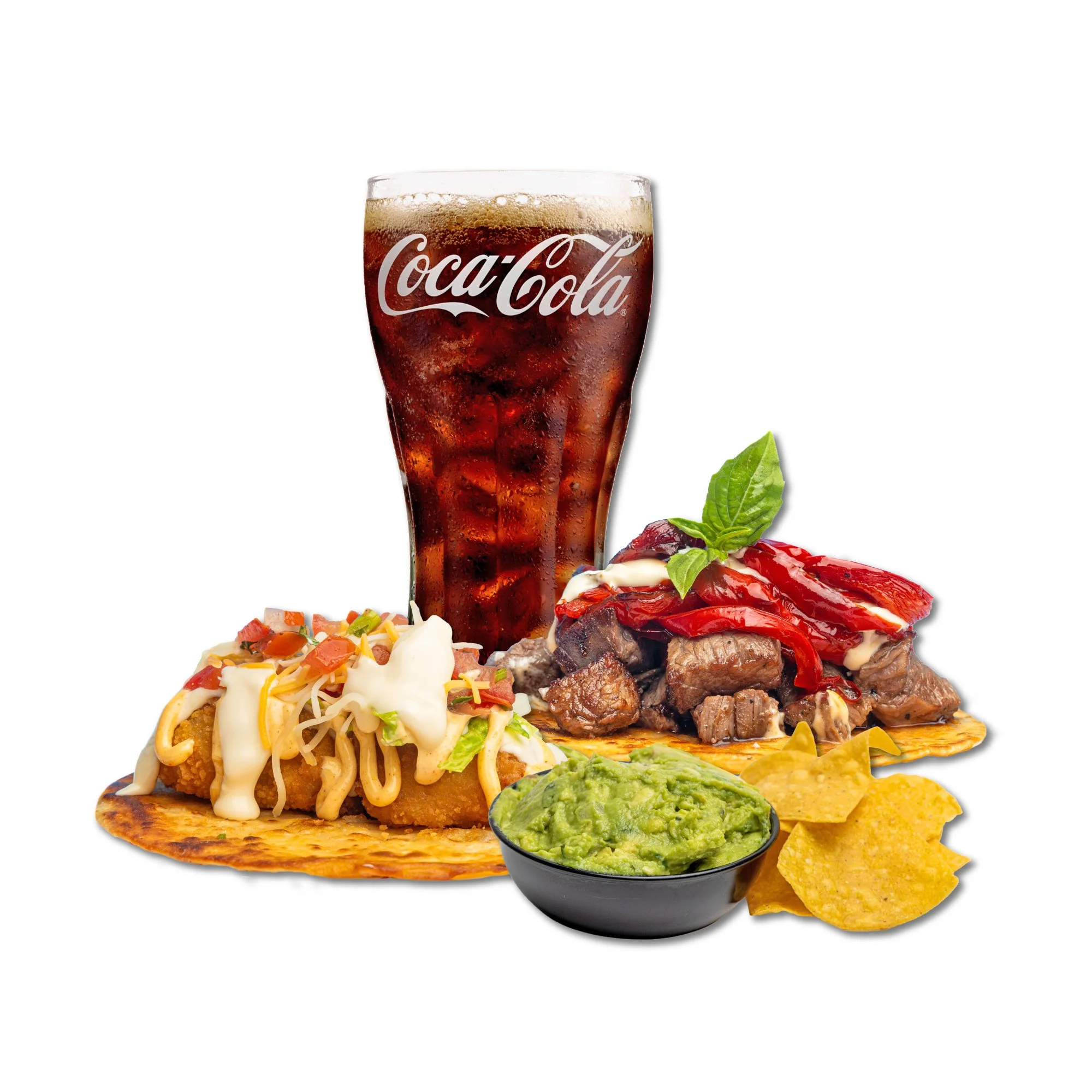 A glass of Coca-Cola with ice behind tacos topped with cheese, vegetables, and sauce, along with guacamole, tortilla chips, and cooked beef with red peppers garnished with a basil leaf.