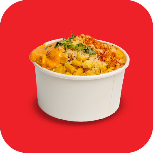 A bowl of loaded mashed potatoes topped with cheese, corn, herbs, and seasoning against a red background.