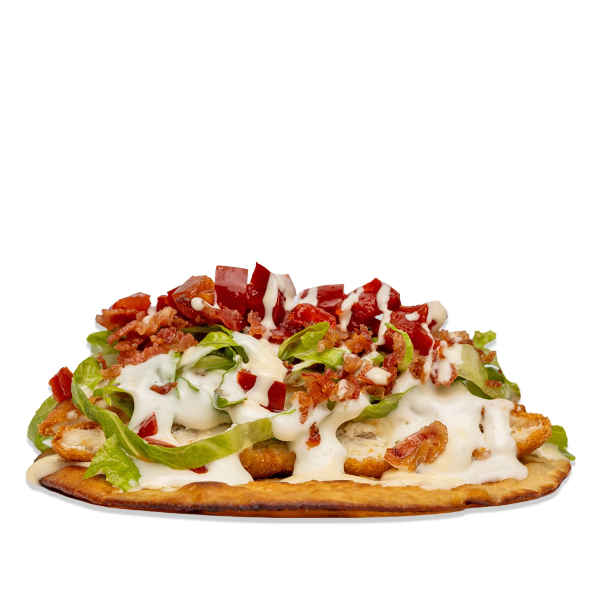 Crispy flatbread taco topped with lettuce, bacon, shredded cheese, diced tomatoes, and dollops of sour cream, isolated on white background.