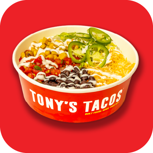Bowl of Mexican-style rice and beans topped with guacamole, sliced jalapeños, sour cream, pickled onions, and corn, on a red background.