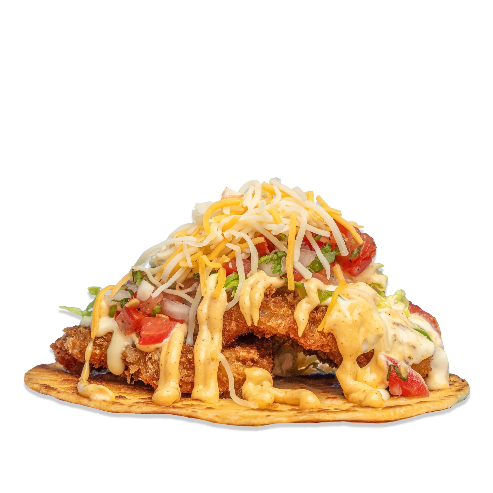 Fried fish taco on a corn tortilla topped with shredded cheese, diced tomatoes, shredded lettuce, and drizzled with creamy sauce.