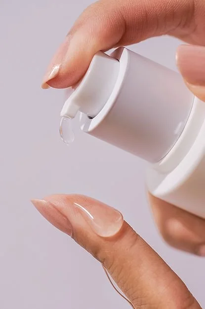 Mano presionando un botón en un dispensador de jabón líquido