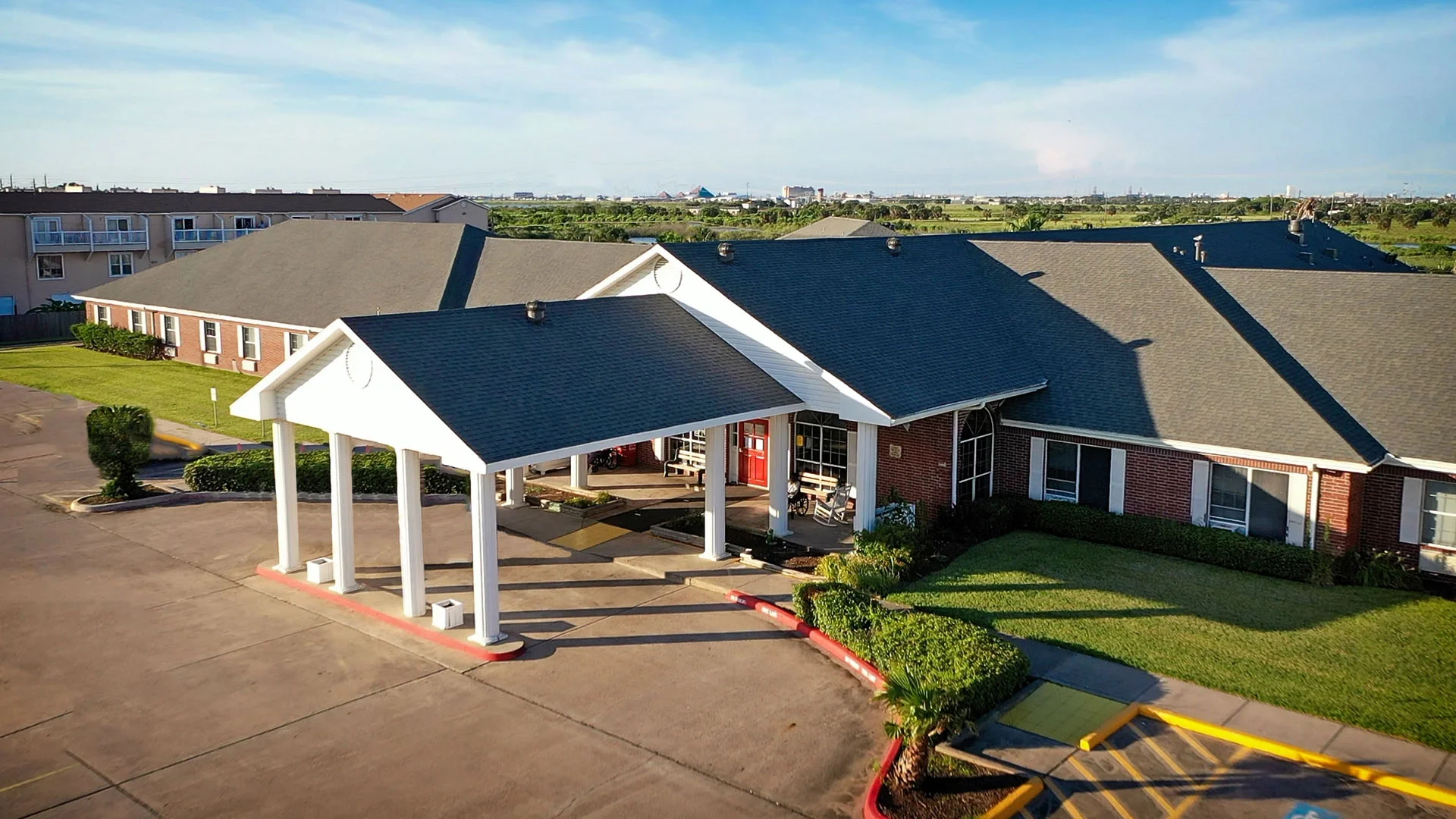 Front view of a one-story building with a covered entrance and landscaped area.