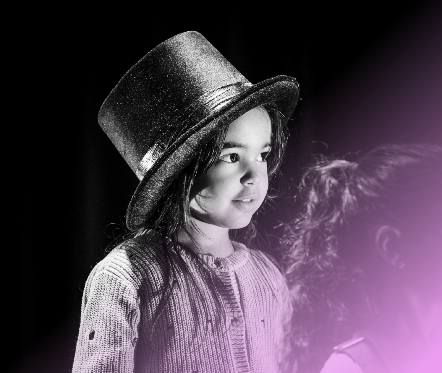 Jeune fille avec un chapeau haut de forme noir, photo en noir et blanc, souriante, portant un pull