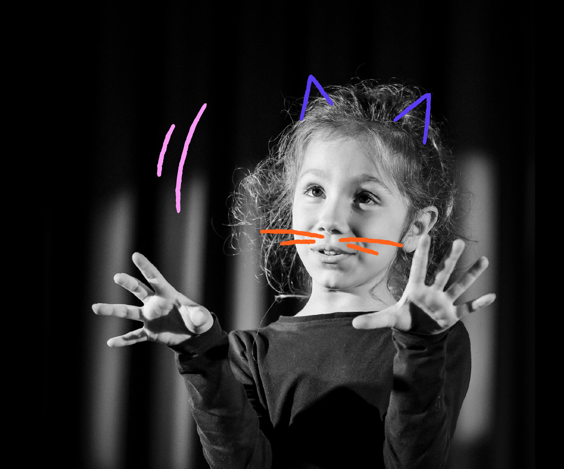 Photo en noir et blanc d'une jeune fille avec des oreilles de chat, un nez et des moustaches dessinés en couleurs sur son visage, tenant ses mains en avant