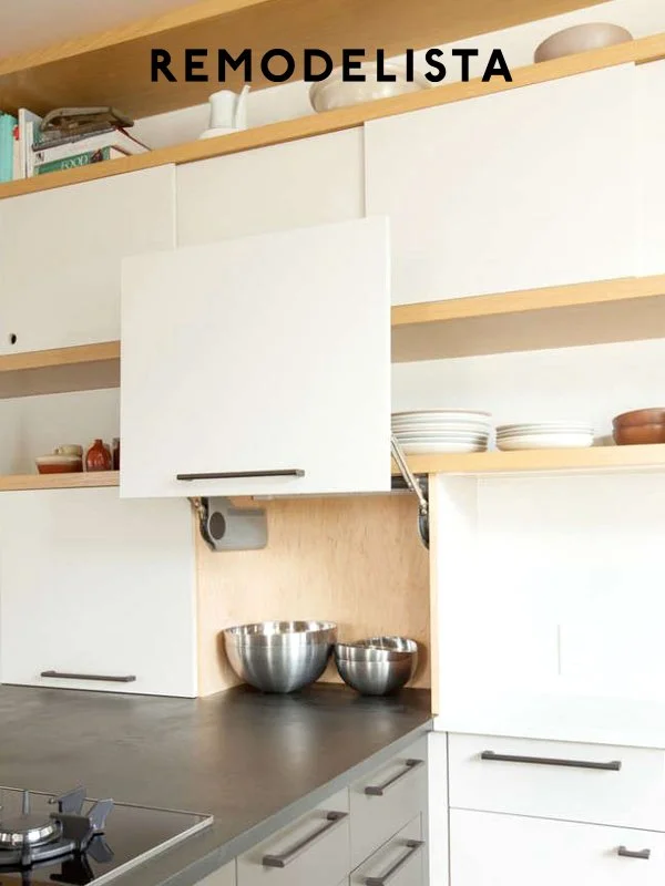 Modern kitchen with white cabinets, wooden open shelves, stainless steel bowls, and a gray countertop.