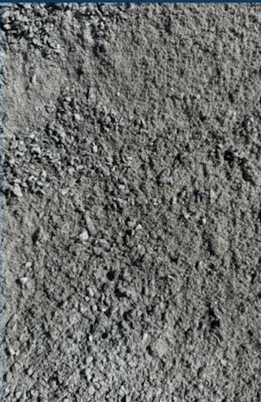 Close-up of rough gray dirt or soil surface with small rocks.