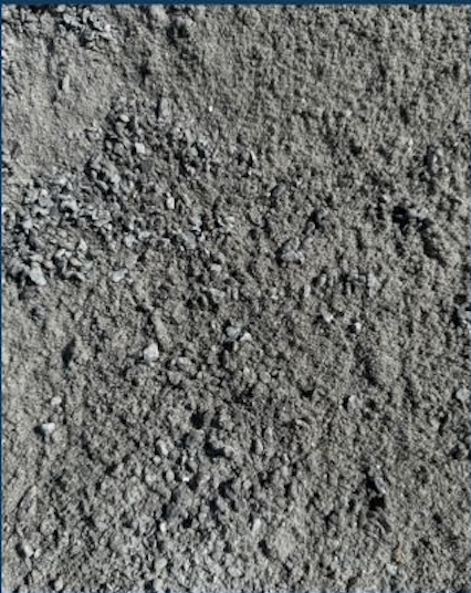 Close-up of gray dirt or soil with small rocks and pebbles